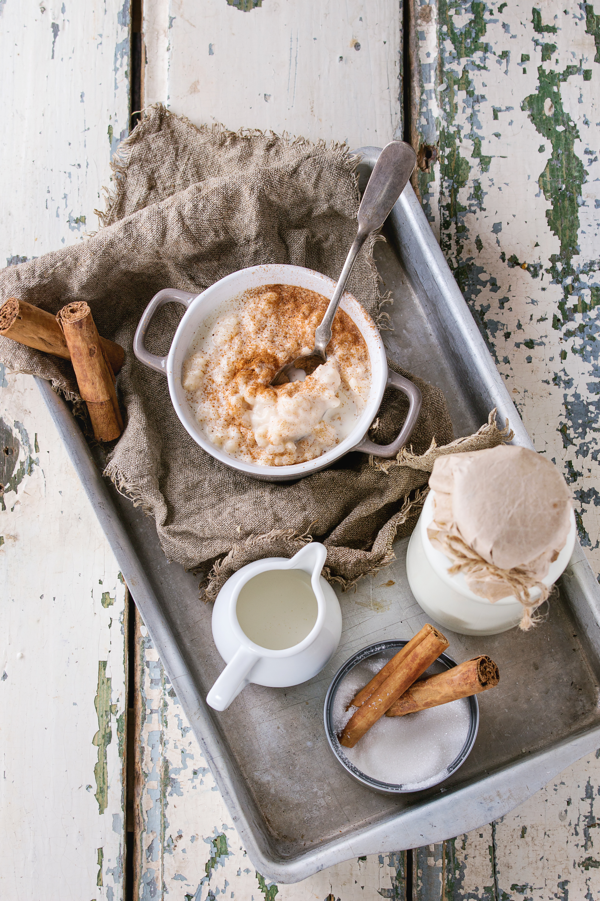 Overhead flat-lay of all ingredients for Honey-Glazed Norwegian Rømmegrøt with Butter and Cinnamon laid out on a kitchen surface.