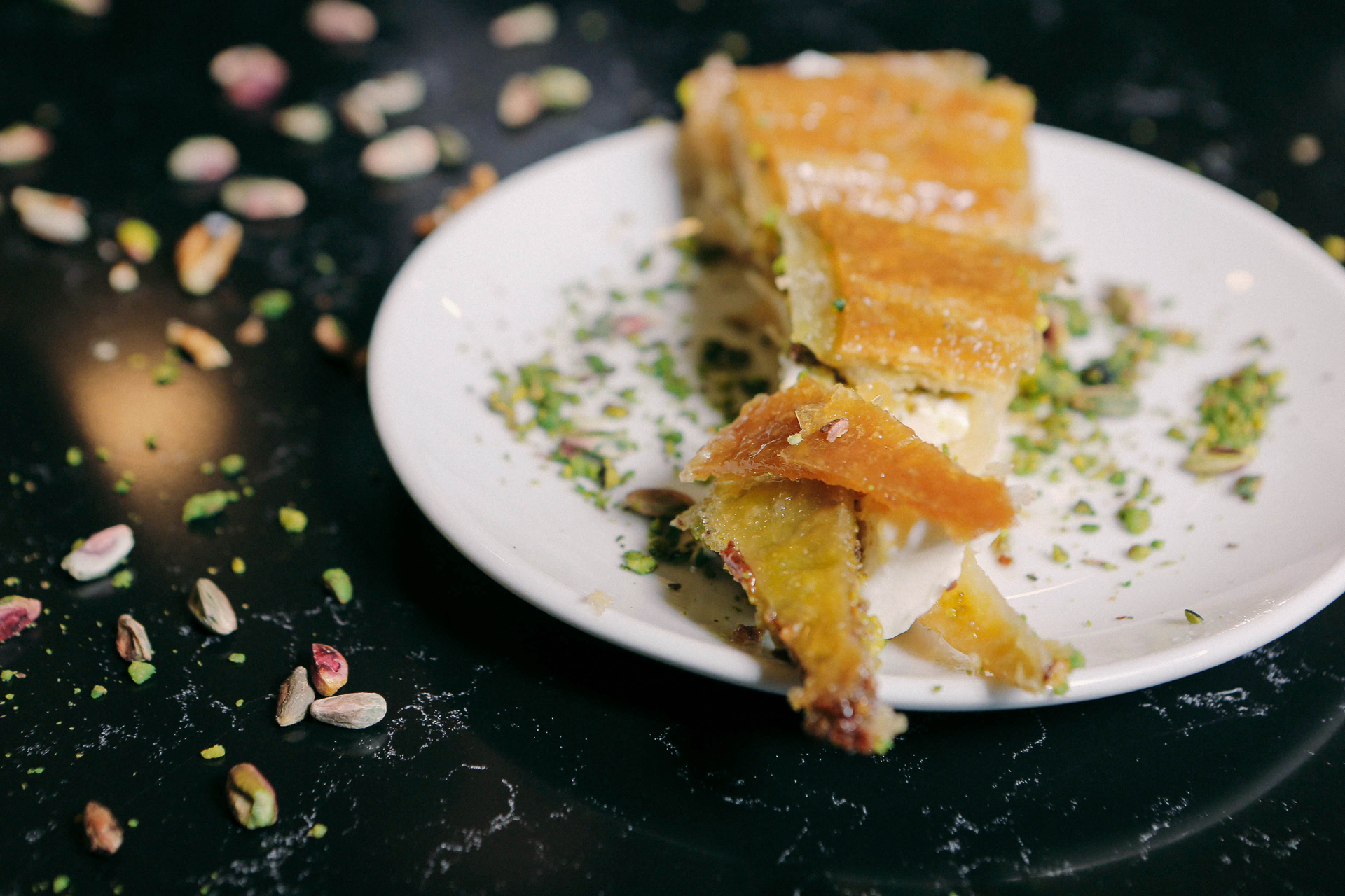 Overhead flat-lay of all ingredients for Honey & Lemon Glazed Greek Baklava with Pistachio laid out on a kitchen surface.