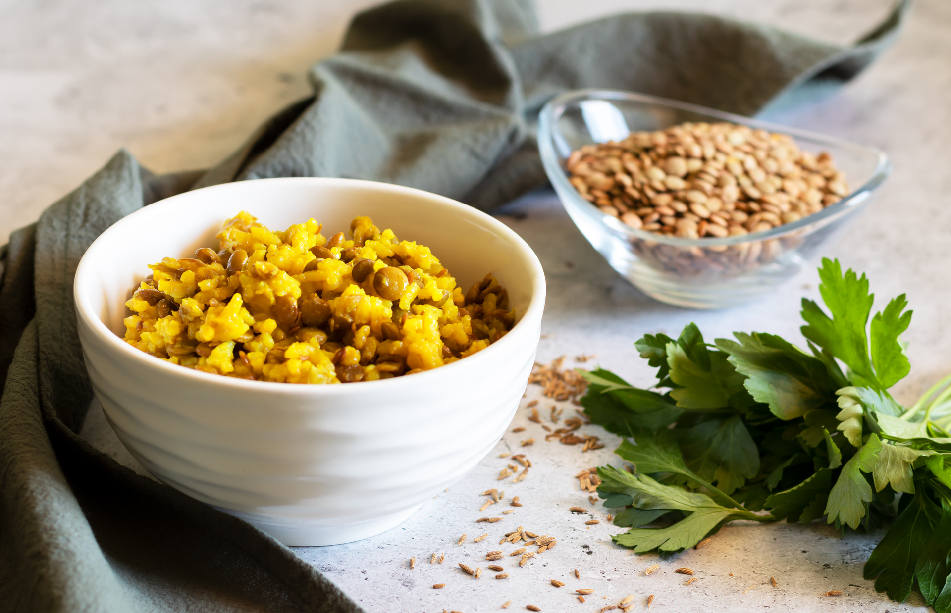 Overhead flat-lay of all ingredients for Indian Turmeric and Mustard Seed Lentil Stew laid out on a kitchen surface.