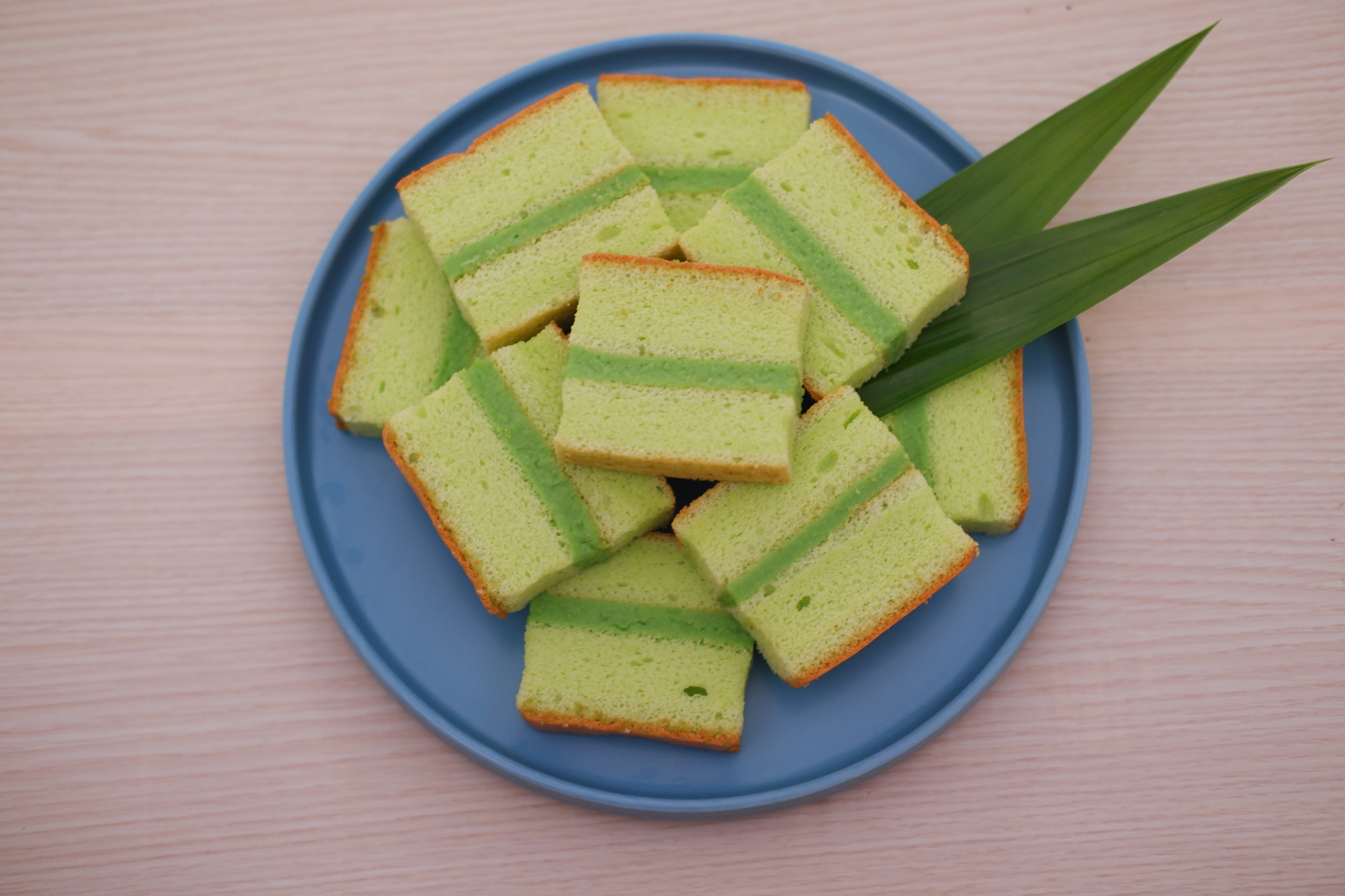 Overhead flat-lay of all ingredients for Indonesian Coconut Pandan Layer Cake laid out on a kitchen surface.