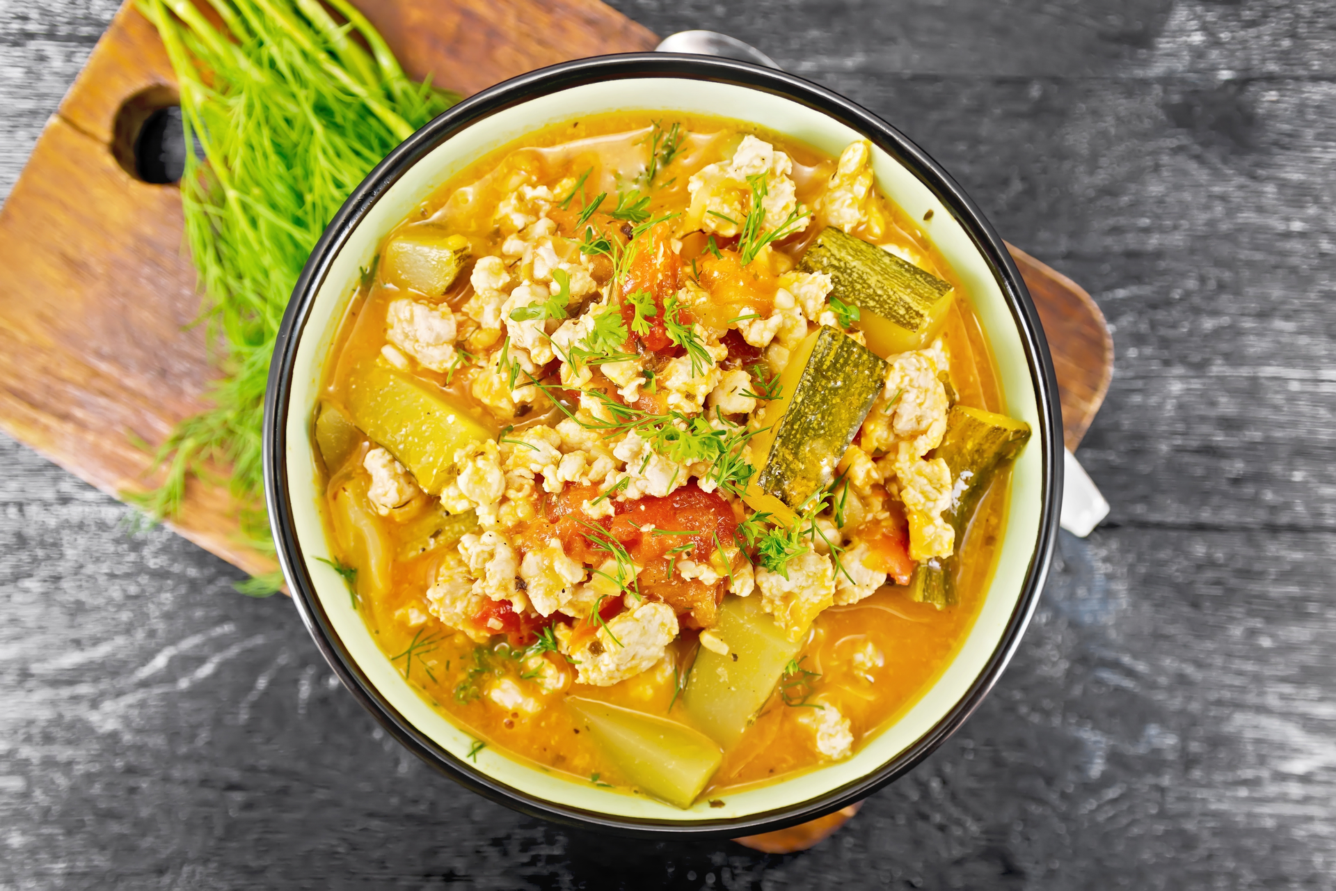 Overhead flat-lay of all ingredients for Indonesian Soto Betawi laid out on a kitchen surface.