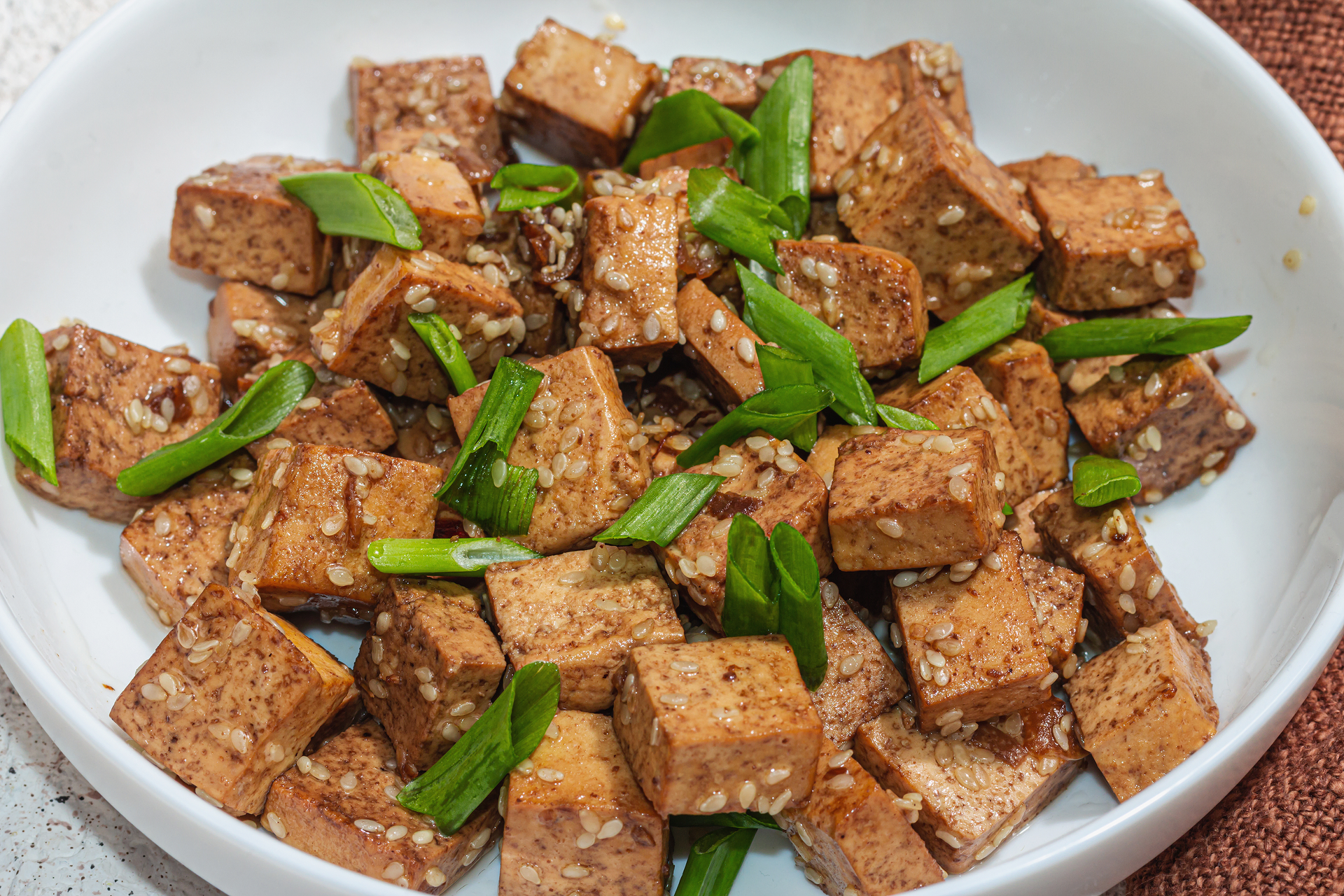 Overhead flat-lay of all ingredients for Indonesian Tempeh Manis in Spicy Sweet Soy Sauce laid out on a kitchen surface.