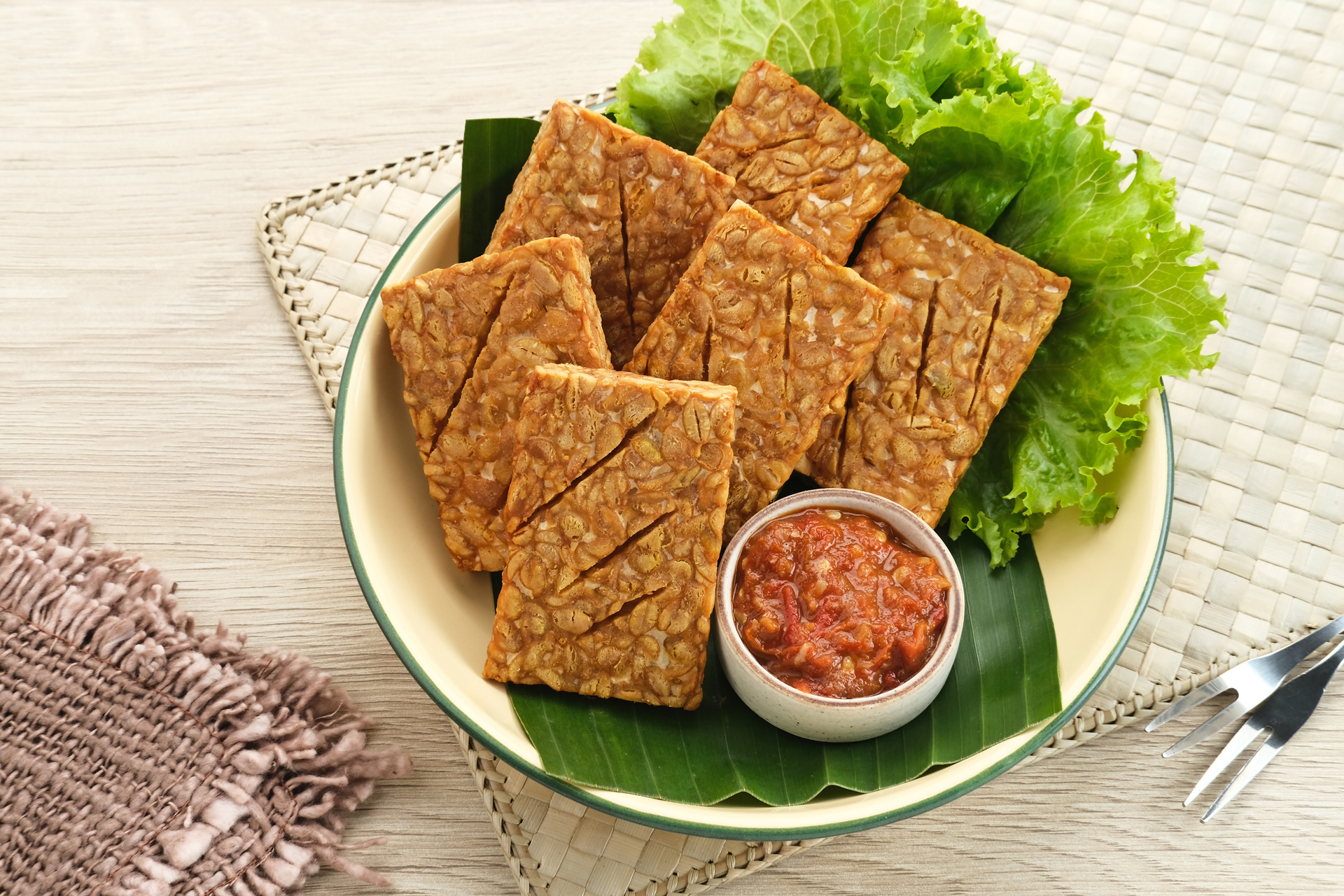 Overhead flat-lay of all ingredients for Indonesian Tempeh Pernik with Spicy Sambal laid out on a kitchen surface.