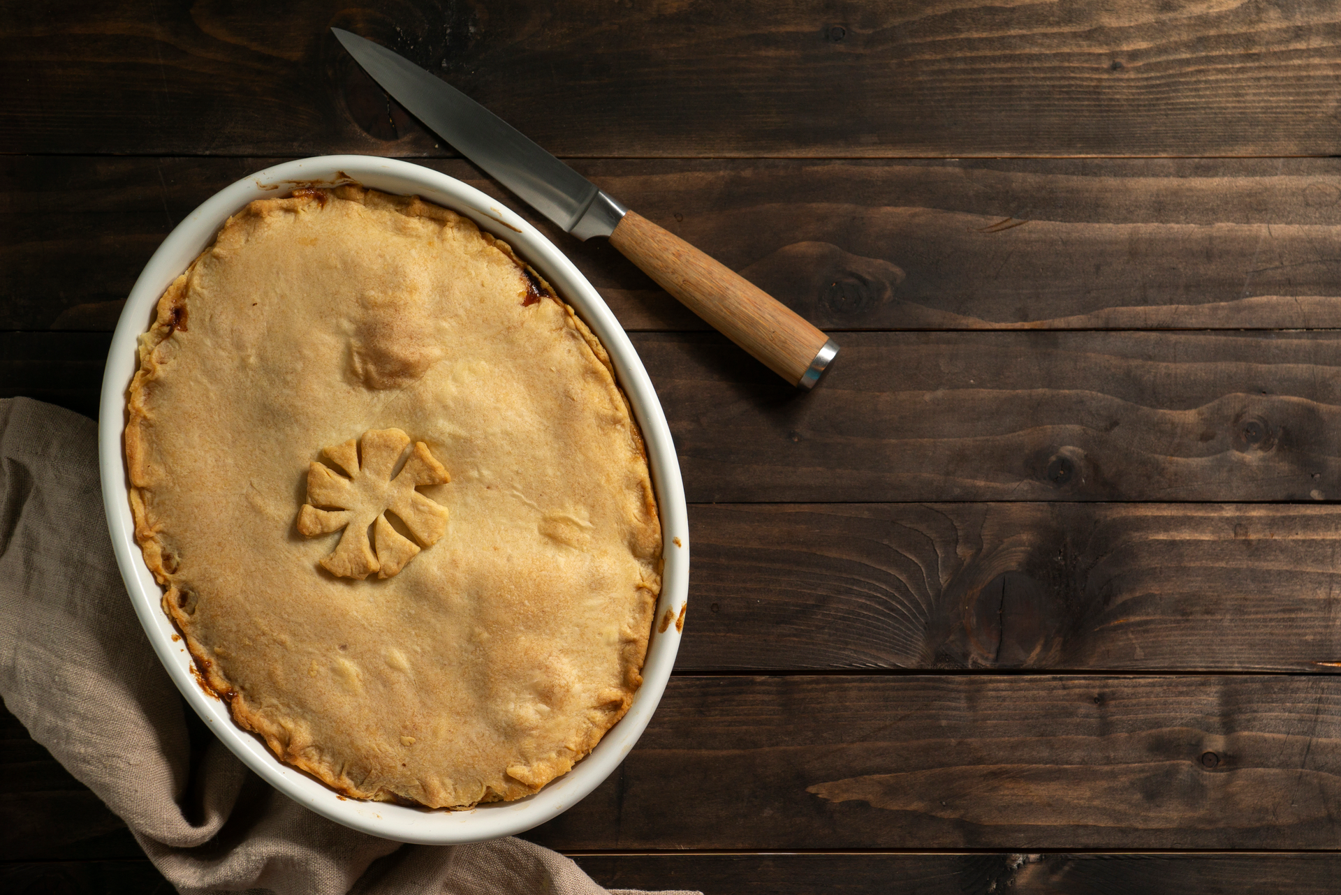 Overhead flat-lay of all ingredients for Irish Guinness Pie with Flaky Pastry laid out on a kitchen surface.