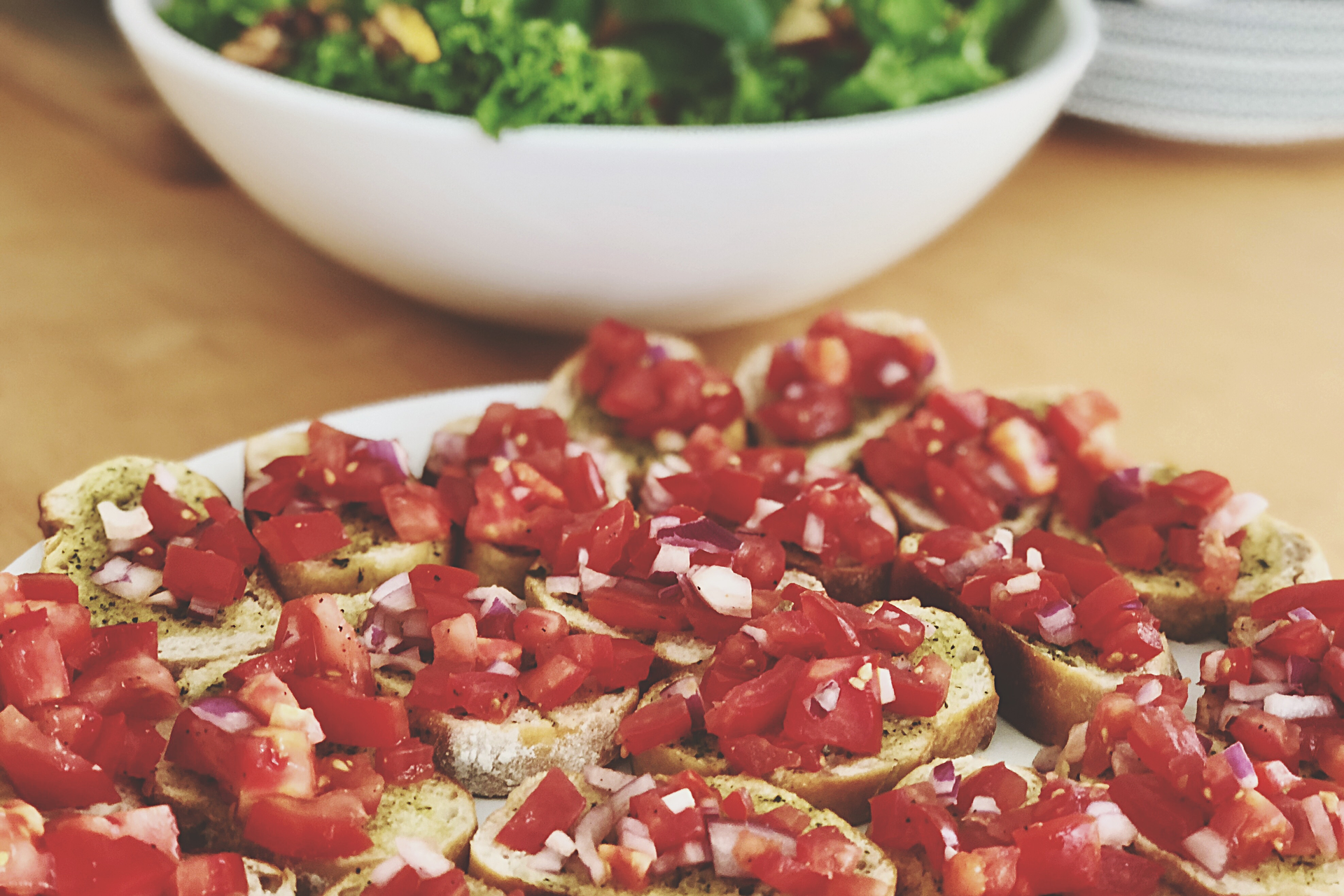 Overhead flat-lay of all ingredients for Italian Feta and Pomegranate Bruschetta with Mint Infusion laid out on a kitchen surface.