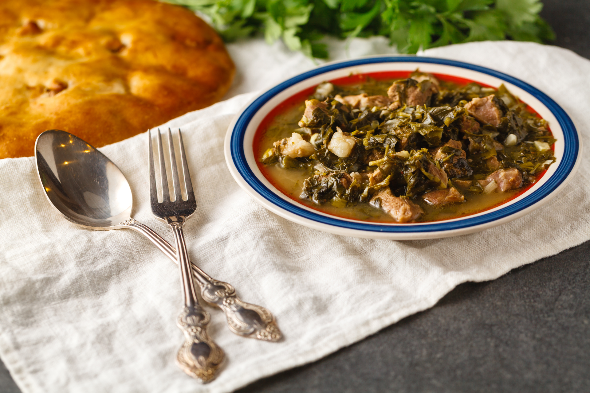 Overhead flat-lay of all ingredients for Jamaican Callaloo with Saltfish laid out on a kitchen surface.