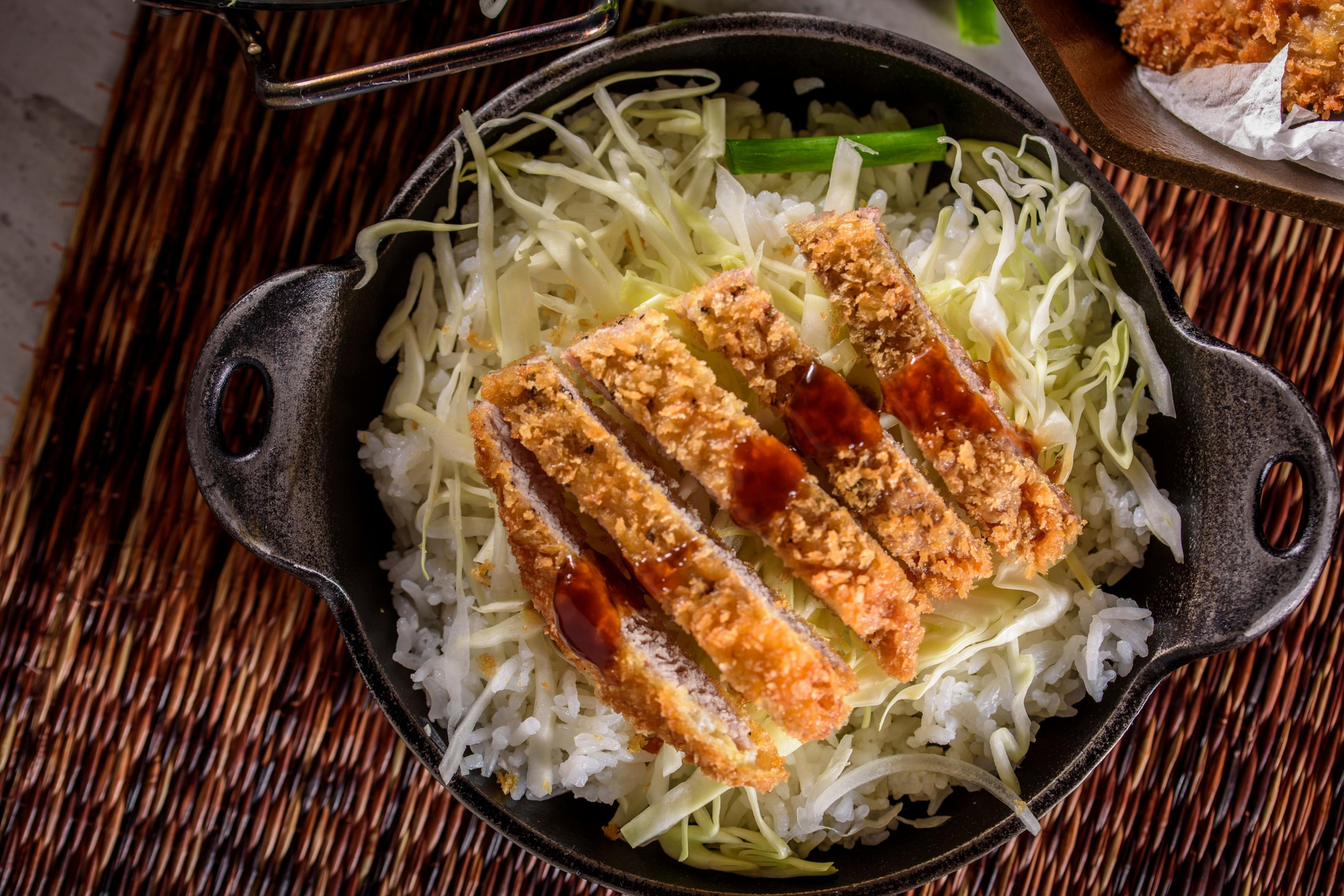 Overhead flat-lay of all ingredients for Japanese Tonkatsu with Cabbage and Tonkatsu Sauce laid out on a kitchen surface.