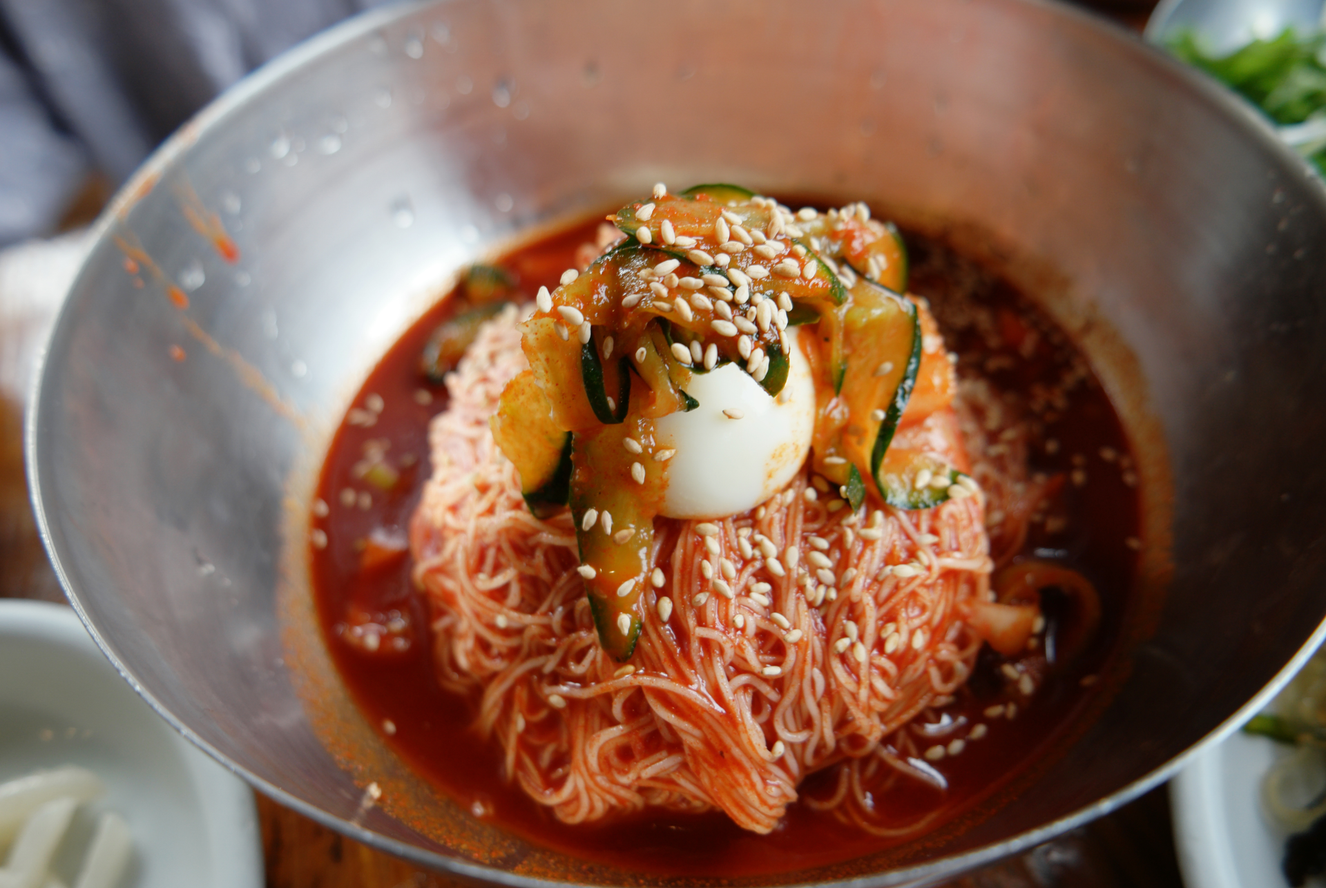 Overhead flat-lay of all ingredients for Korean Bibim Naengmyeon laid out on a kitchen surface.