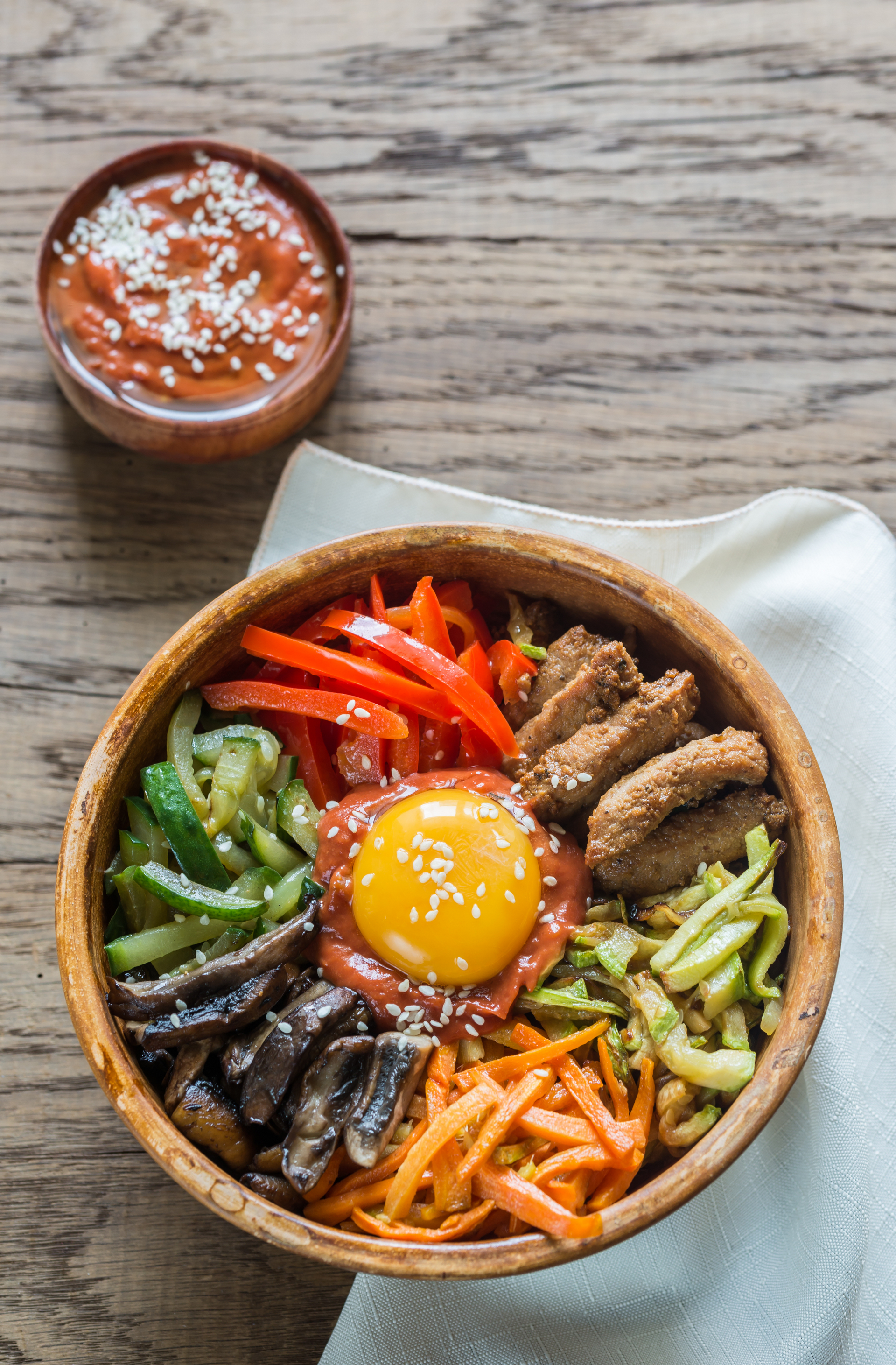 Overhead flat-lay of all ingredients for Korean Bibimbap with Gochujang and Marinated Vegetables laid out on a kitchen surface.