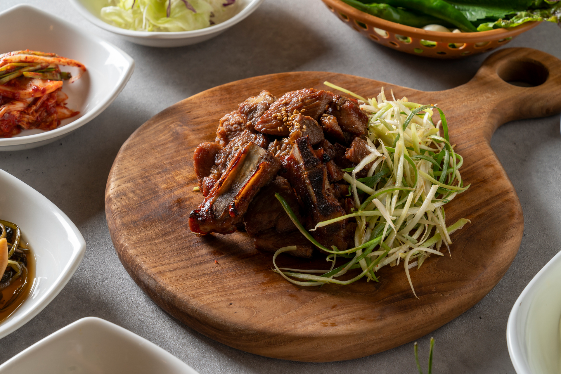 Overhead flat-lay of all ingredients for Korean Chili-Spice Braised Short Ribs with Kimchi Slaw laid out on a kitchen surface.