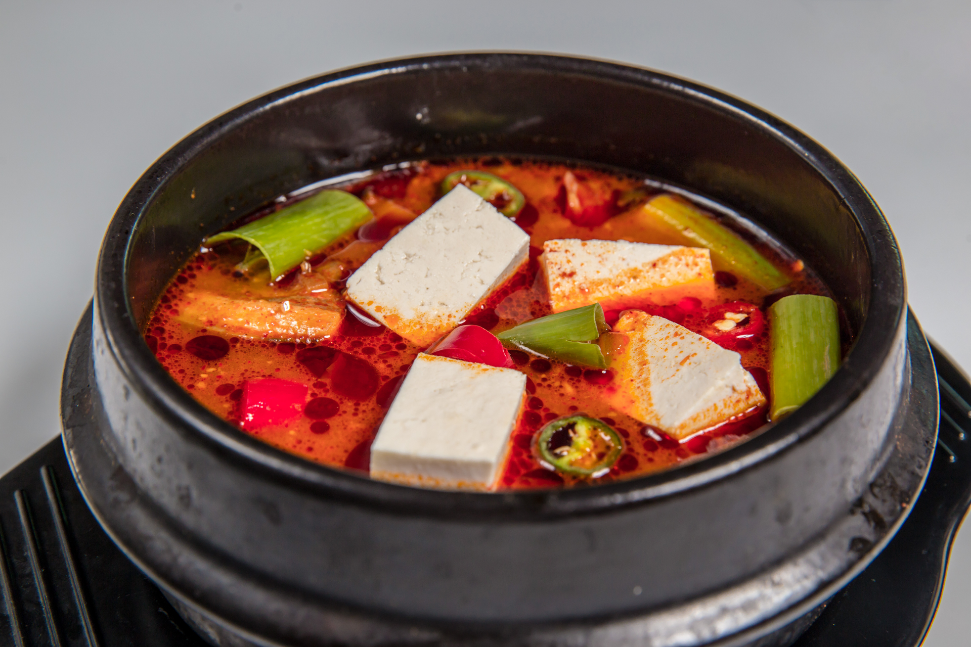 Overhead flat-lay of all ingredients for Korean Kimchi and Pork Hotpot with Silken Tofu laid out on a kitchen surface.