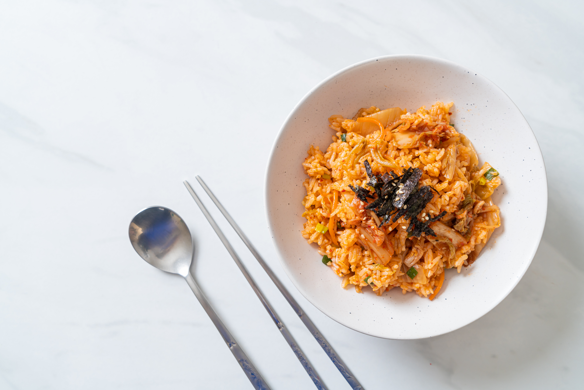 Overhead flat-lay of all ingredients for Korean Kimchi Fried Rice with Crunchy Seaweed laid out on a kitchen surface.