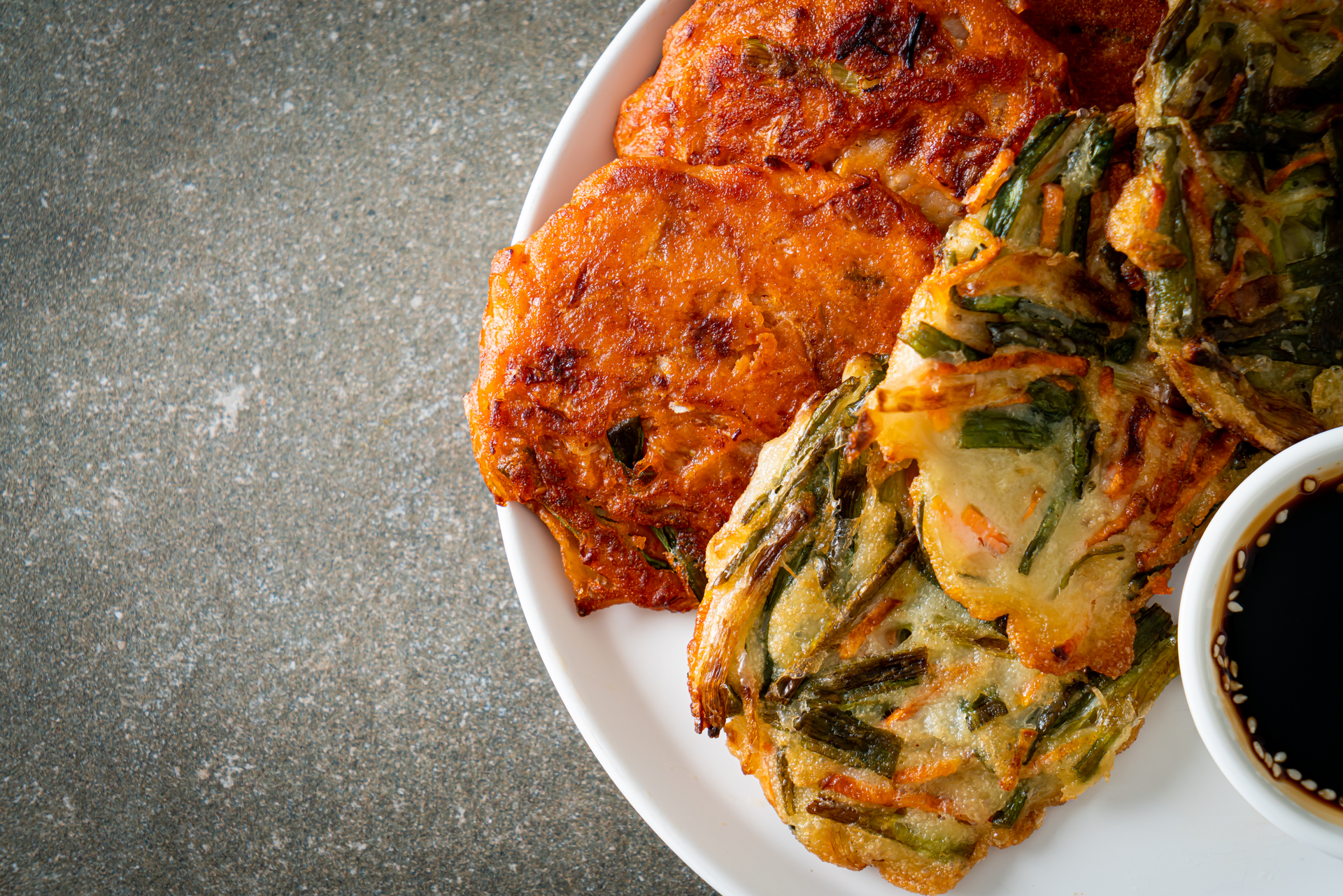 Overhead flat-lay of all ingredients for Korean Kimchi Pancake with Seafood Medley laid out on a kitchen surface.