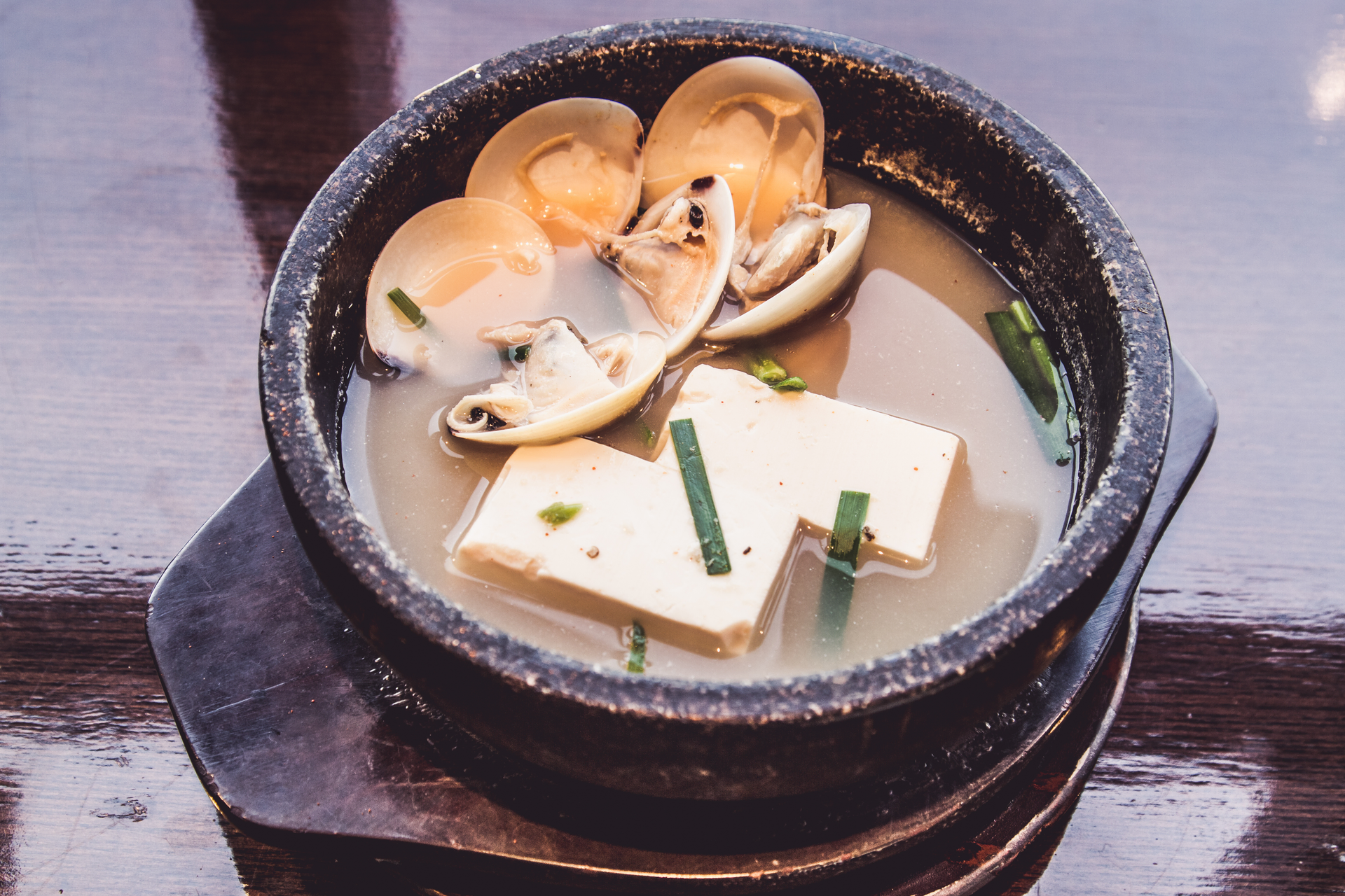 Overhead flat-lay of all ingredients for Korean Sundubu Jjigae with Silken Tofu and Clams laid out on a kitchen surface.