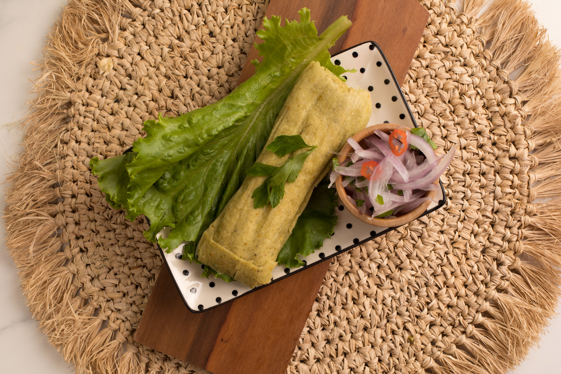 Overhead flat-lay of all ingredients for Lao Crispy Coconut Pancakes with Turmeric Leaf Wrapping laid out on a kitchen surface.