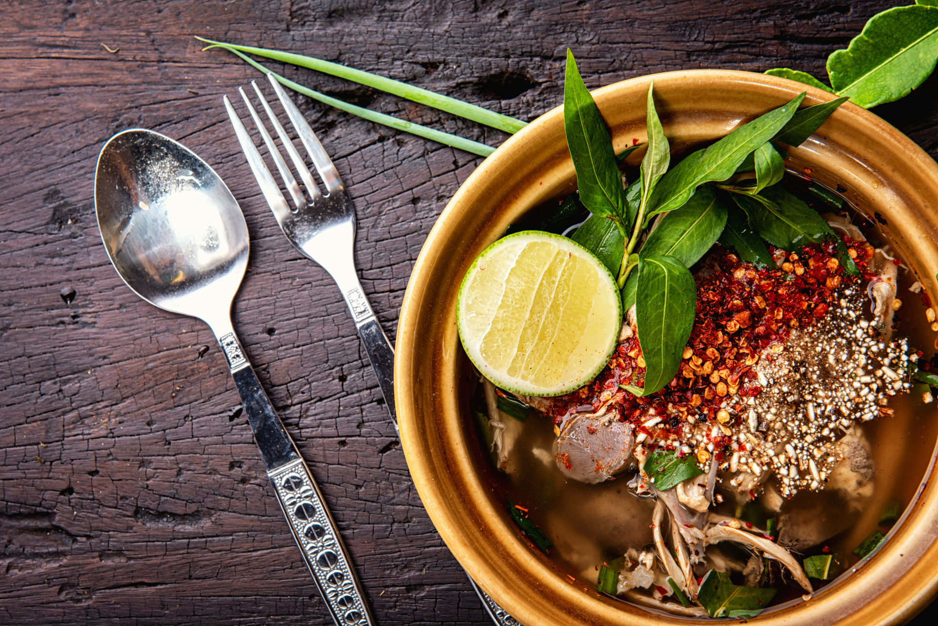 Overhead flat-lay of all ingredients for Lemon-Thyme Infused Vietnamese Pho with Star Anise laid out on a kitchen surface.