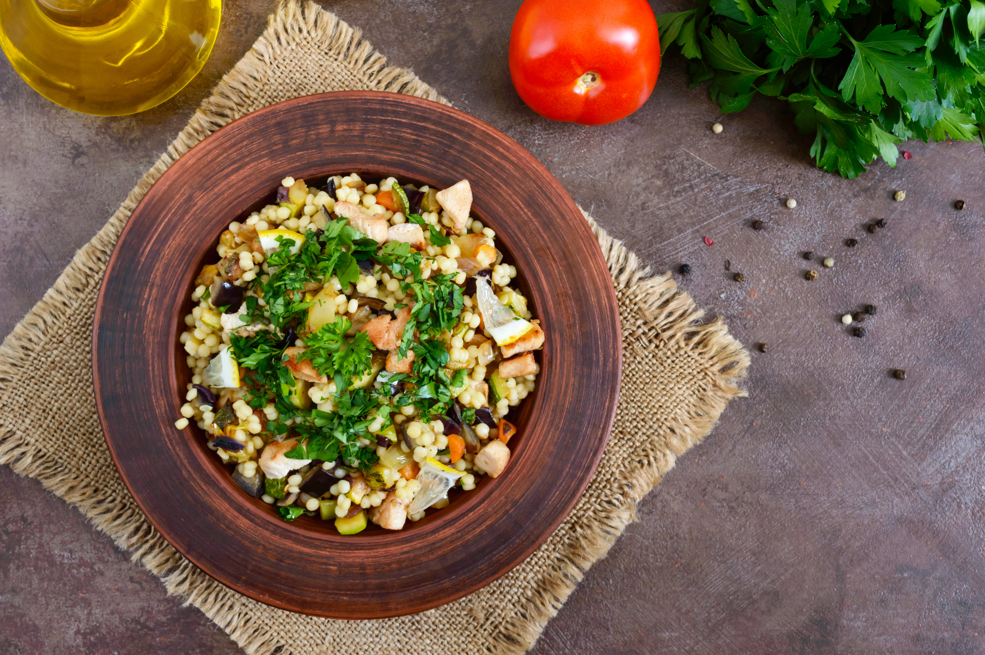 Overhead flat-lay of all ingredients for Lemony Israeli Couscous with Artichokes and Feta laid out on a kitchen surface.