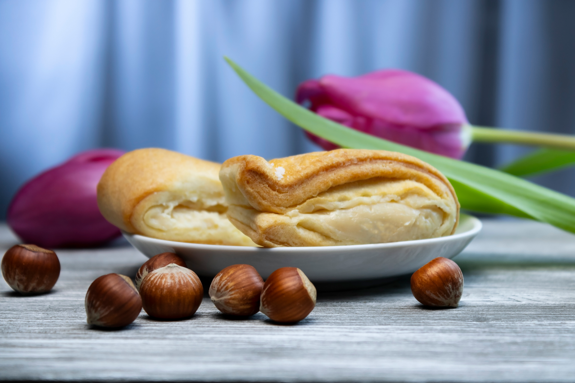 Overhead flat-lay of all ingredients for Luscious French Madeleines with Hazelnut Spread laid out on a kitchen surface.