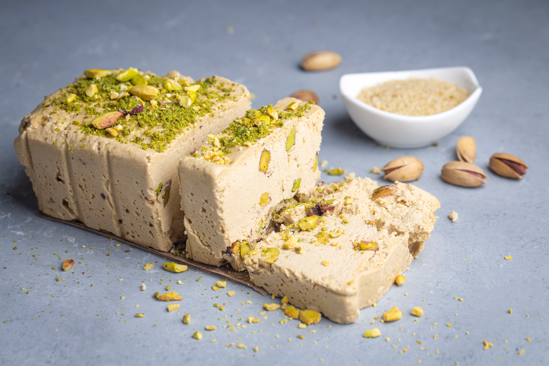 Overhead flat-lay of all ingredients for Luscious Persian Tahini Halva with Pistachio Crunch laid out on a kitchen surface.