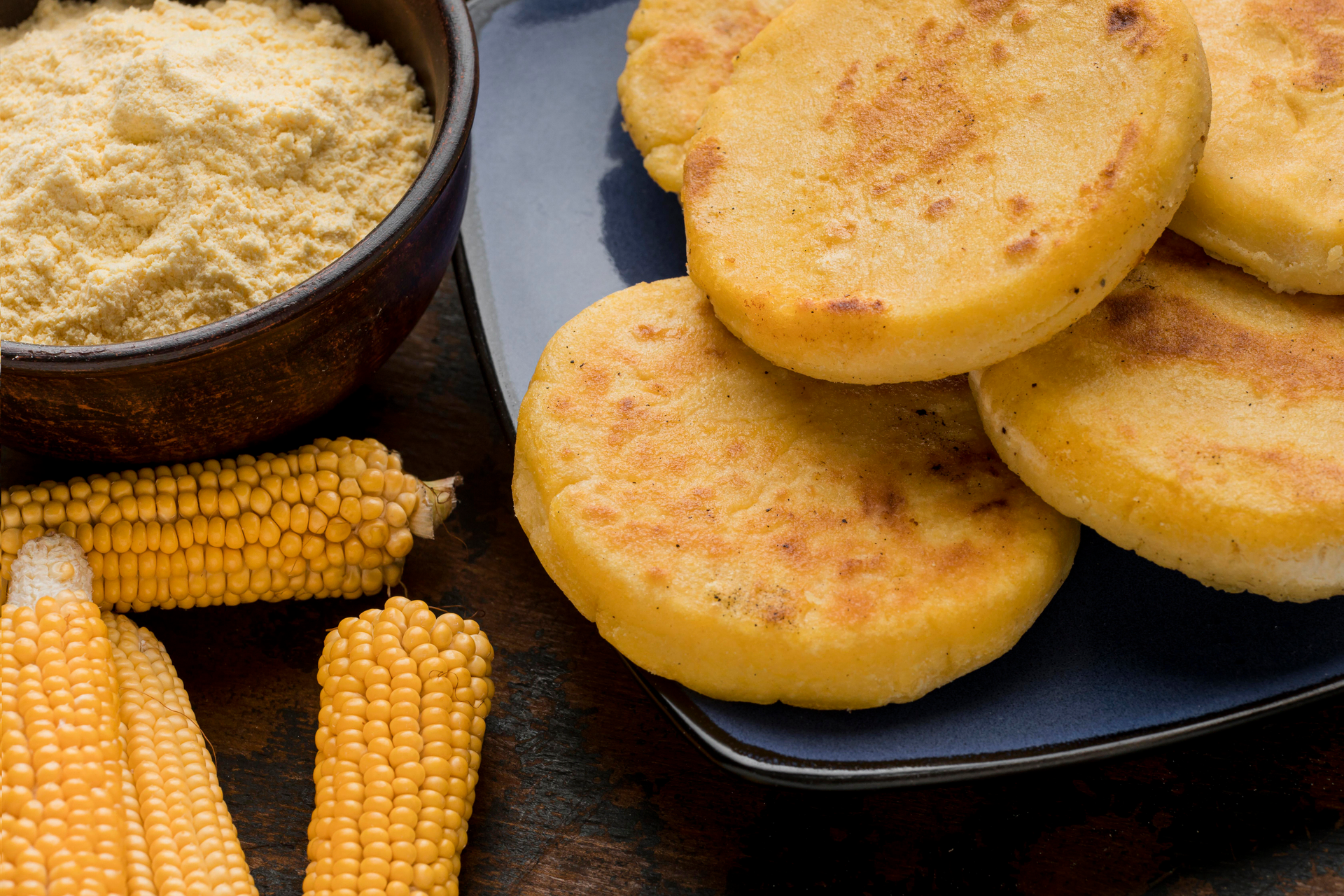 Overhead flat-lay of all ingredients for Lush Colombian Arepas de Choclo with Queso Fresco laid out on a kitchen surface.
