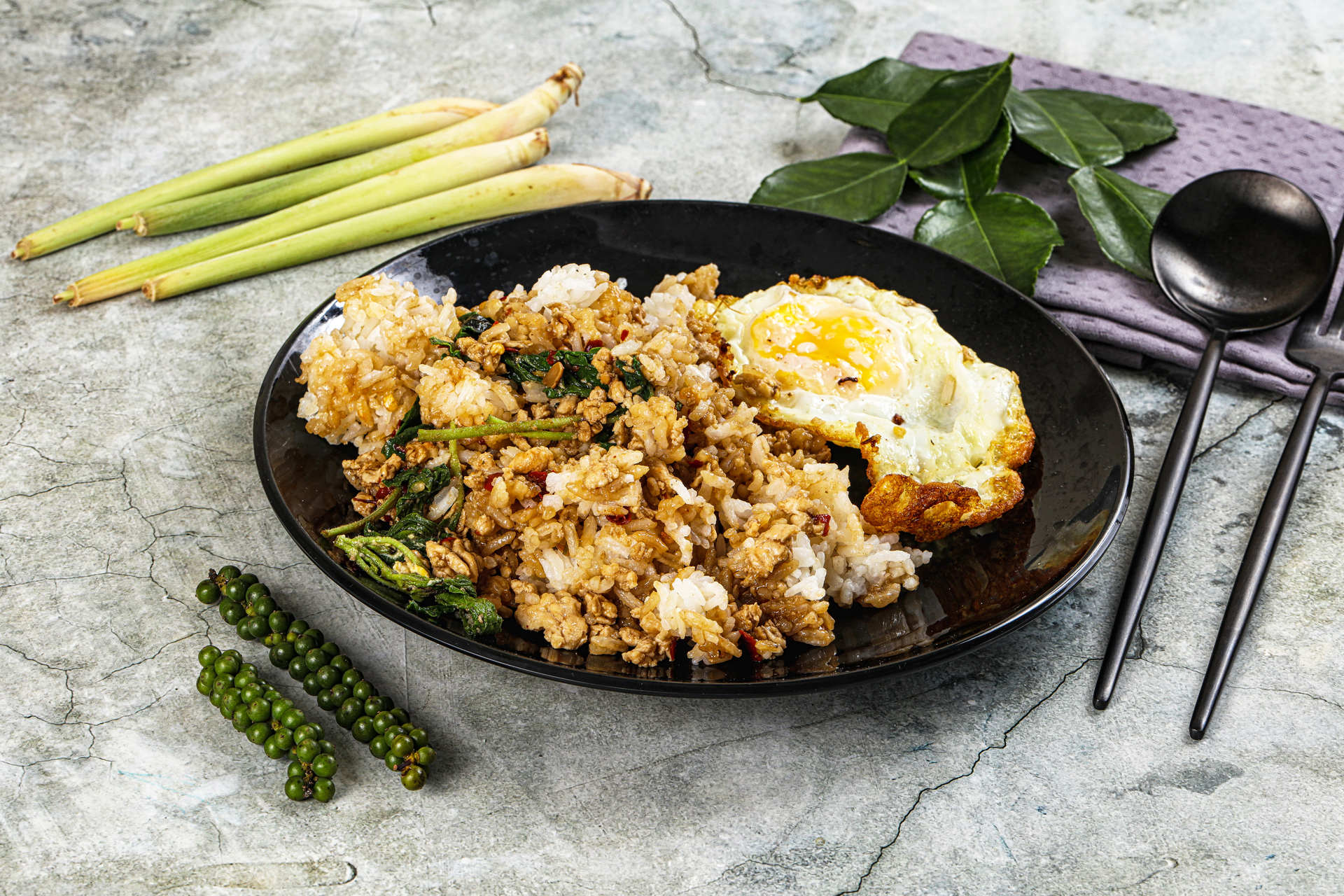 Overhead flat-lay of all ingredients for Luxurious Thai Basil Fried Rice with Sweet Soy Sauce laid out on a kitchen surface.