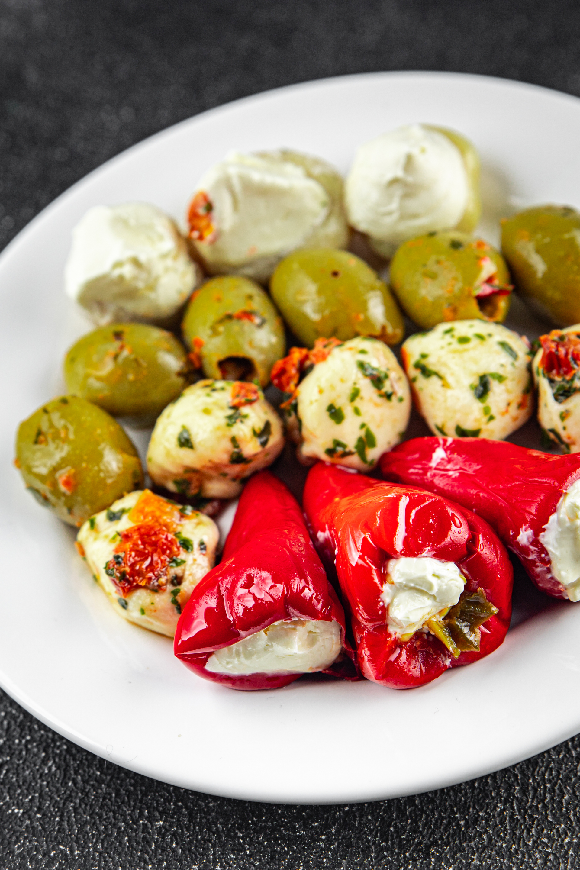 Overhead flat-lay of all ingredients for Mediterranean Feta and Olive-Stuffed Mini Peppers laid out on a kitchen surface.