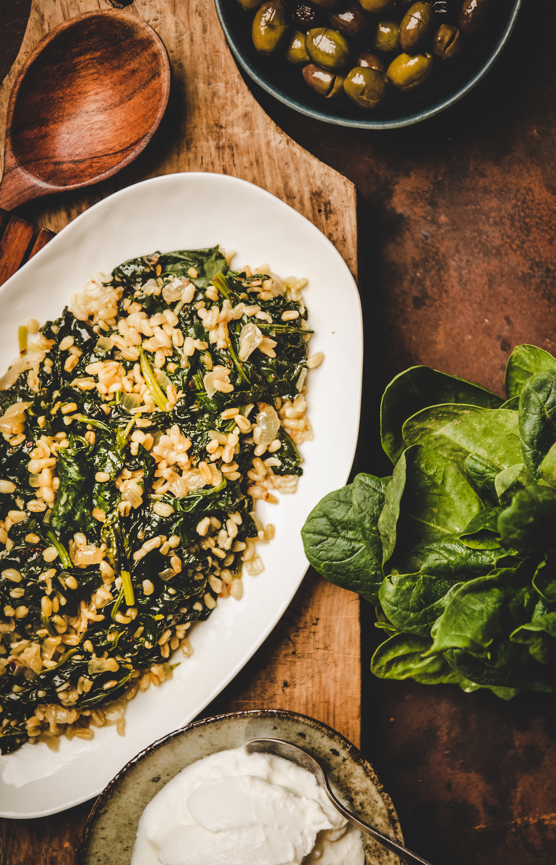 Overhead flat-lay of all ingredients for Mediterranean chickpea salad with fresh herbs laid out on a kitchen surface.