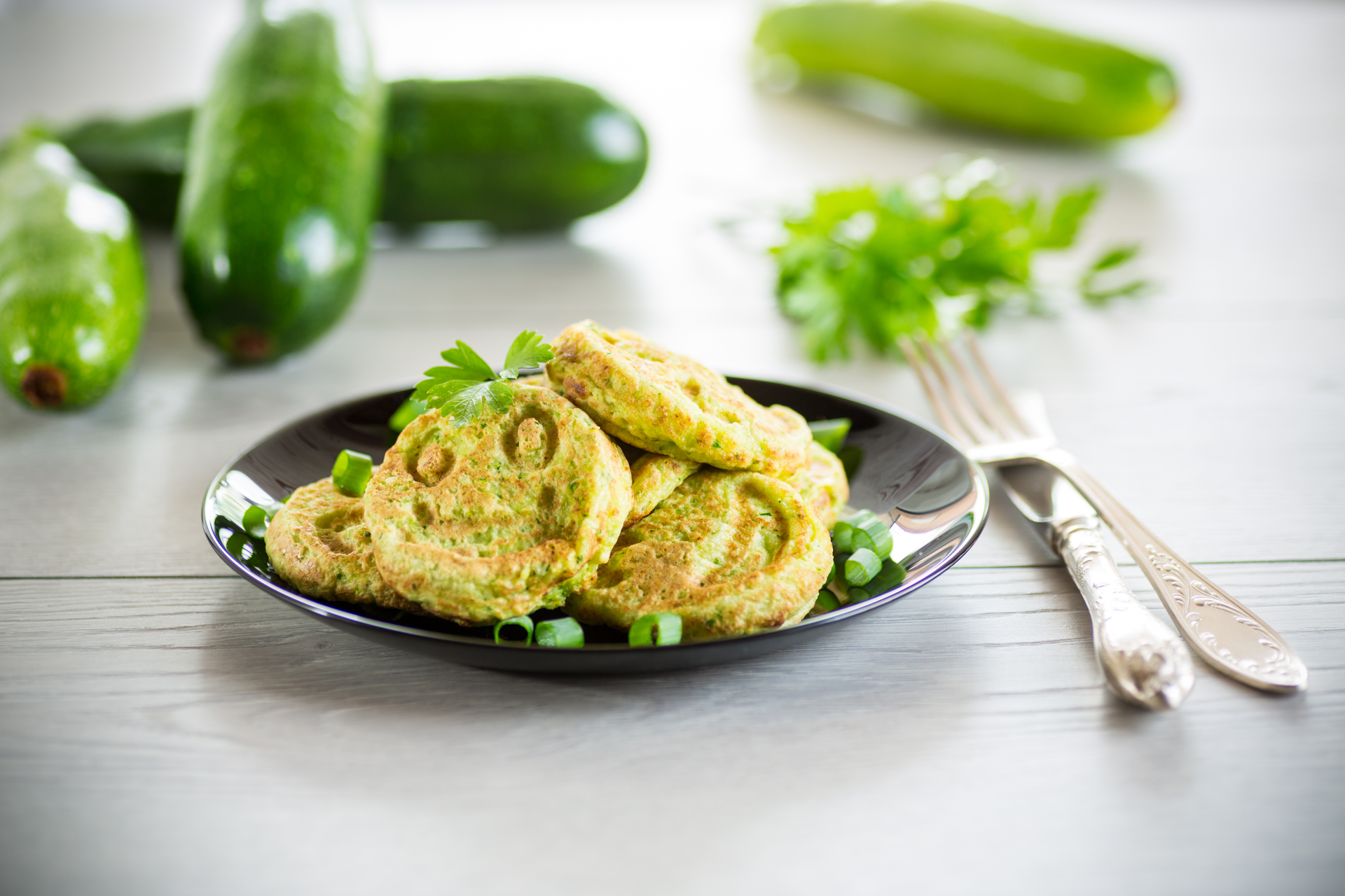 Overhead flat-lay of all ingredients for Mediterranean Zucchini Fritters with Feta and Mint laid out on a kitchen surface.