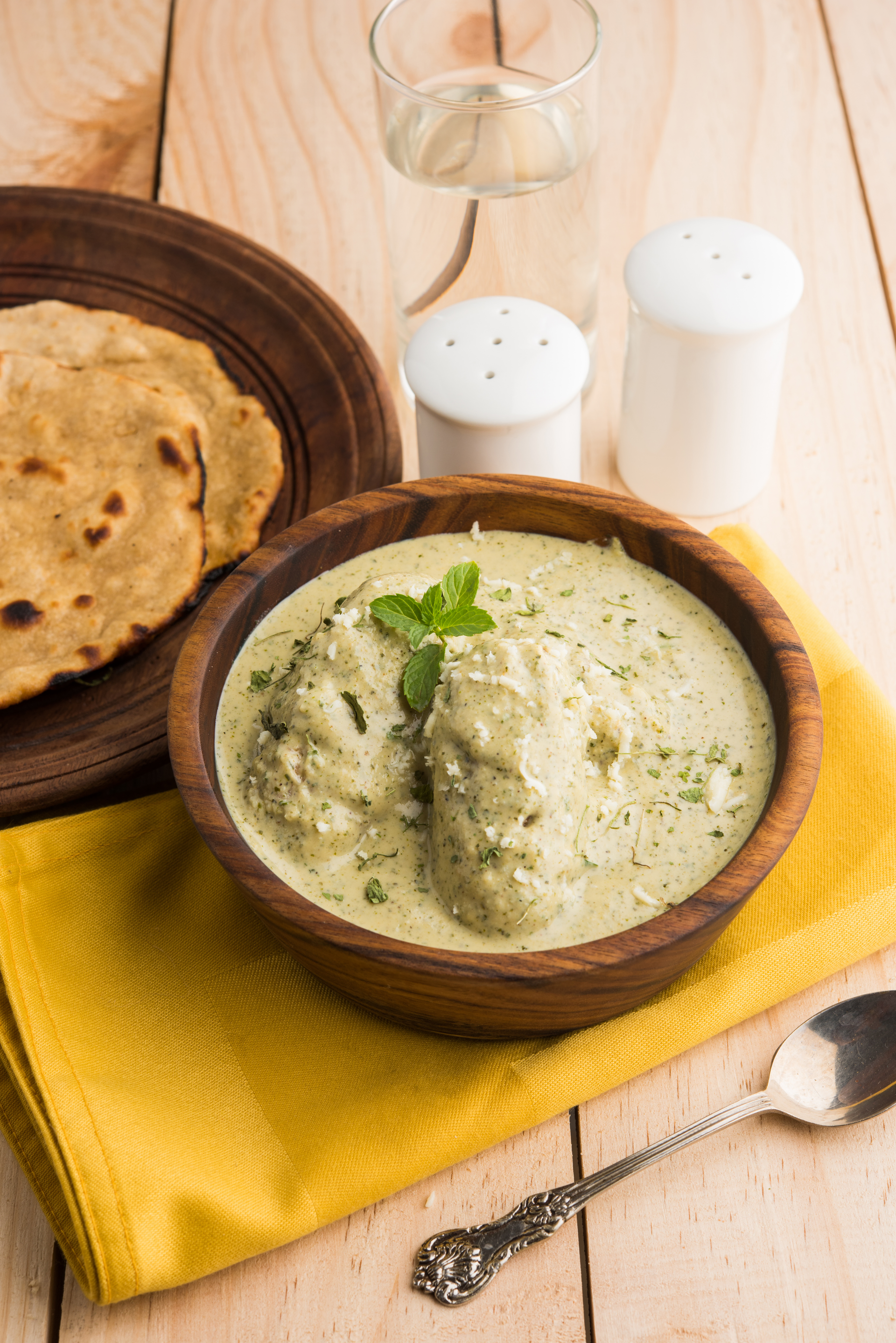 Overhead flat-lay of all ingredients for Methi Malai Murg with Fenugreek Leaves laid out on a kitchen surface.