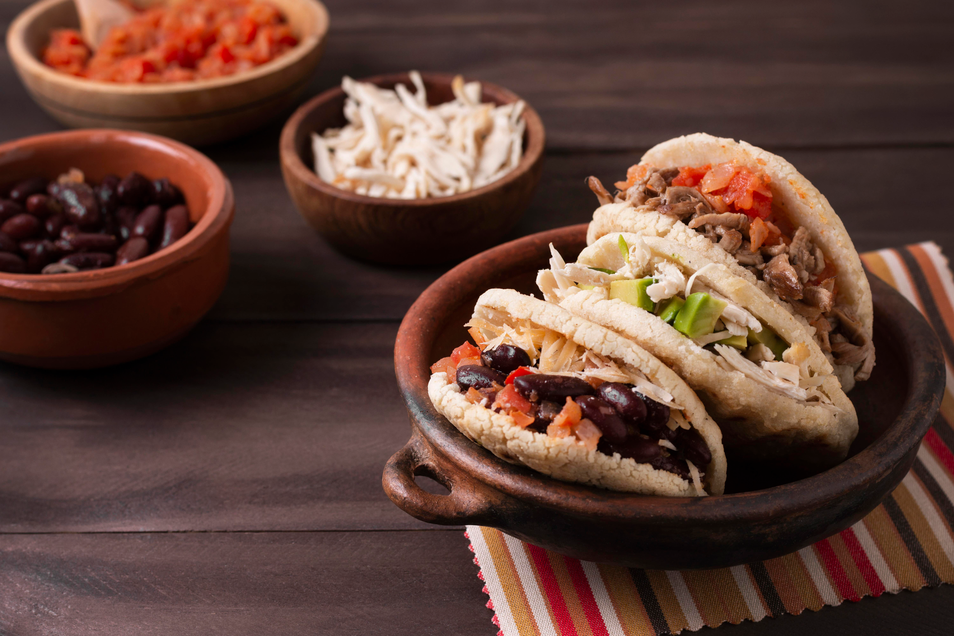 Overhead flat-lay of all ingredients for Mexican Tinga de Pollo with Chipotle Peppers laid out on a kitchen surface.