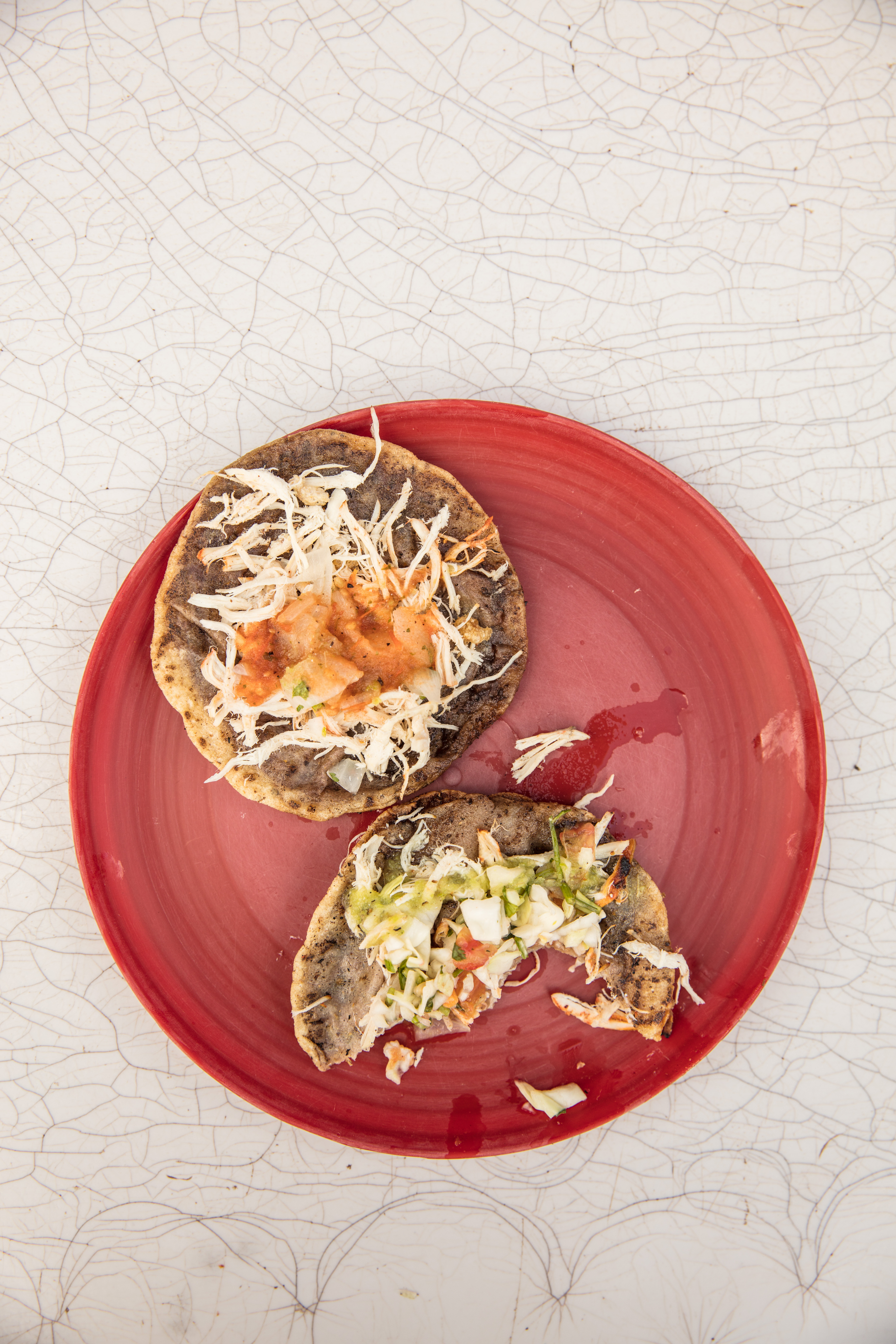 Overhead flat-lay of all ingredients for Mexican Tlayuda with Refried Beans and Oaxacan Cheese laid out on a kitchen surface.