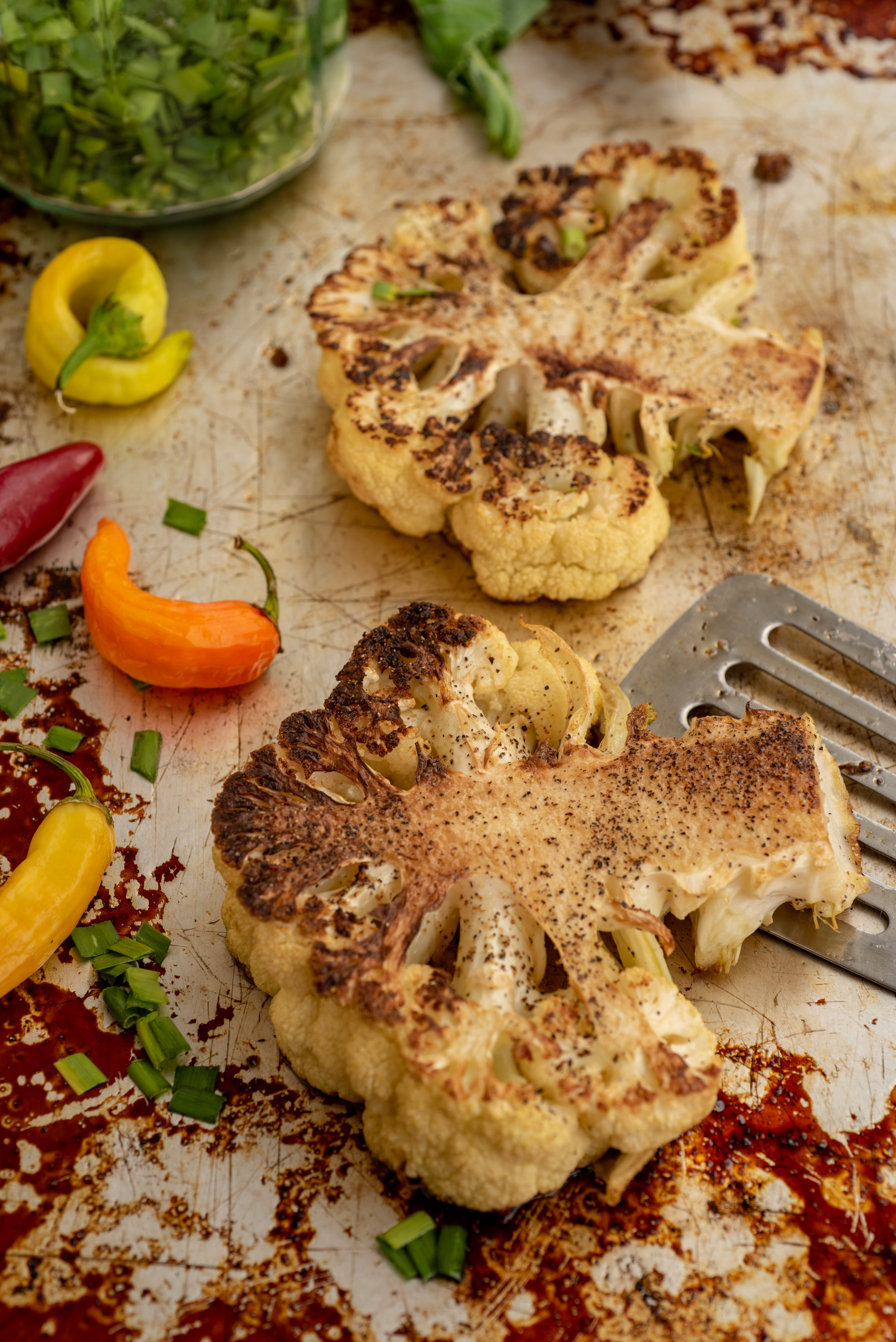 Overhead flat-lay of all ingredients for Middle Eastern Shawarma Spiced Cauliflower with Tahini Drizzle laid out on a kitchen surface.
