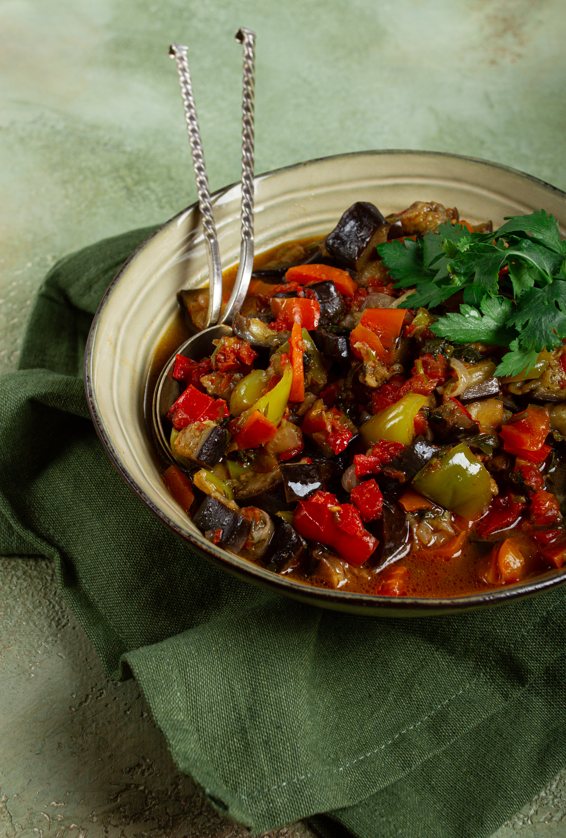 Overhead flat-lay of all ingredients for Moroccan Eggplant and Pomegranate Stew with Almond Garnish laid out on a kitchen surface.