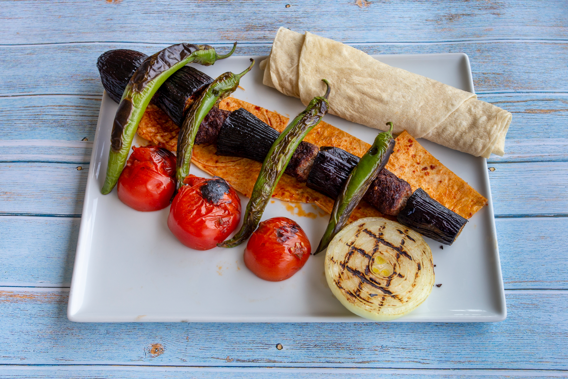 Overhead flat-lay of all ingredients for Moroccan Harissa Rubbed Grilled Eggplant with Feta Cheese laid out on a kitchen surface.