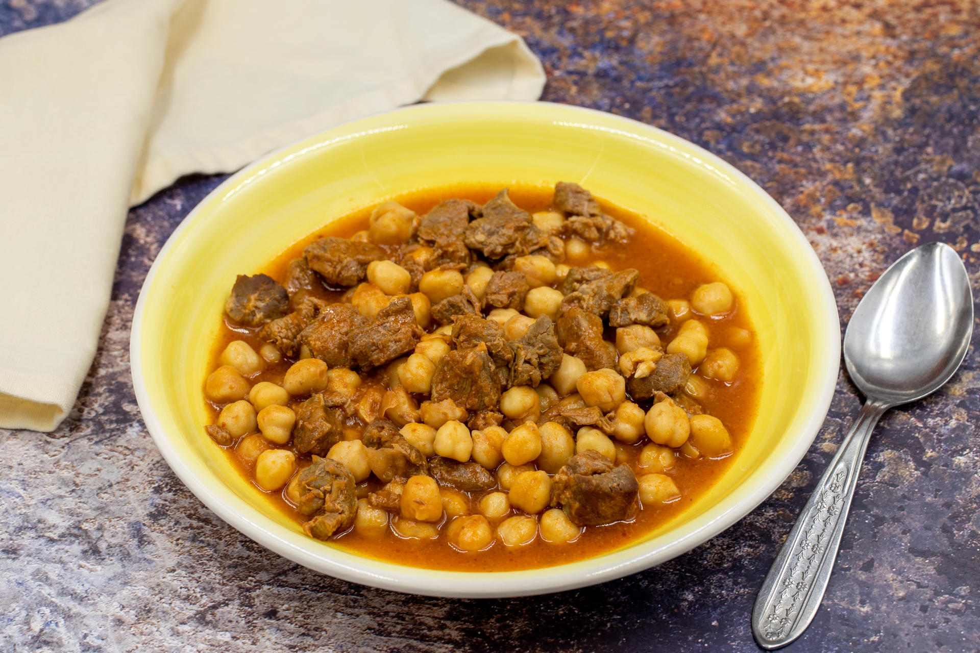 Overhead flat-lay of all ingredients for Moroccan Lamb Harira with Chickpeas and Cinnamon laid out on a kitchen surface.