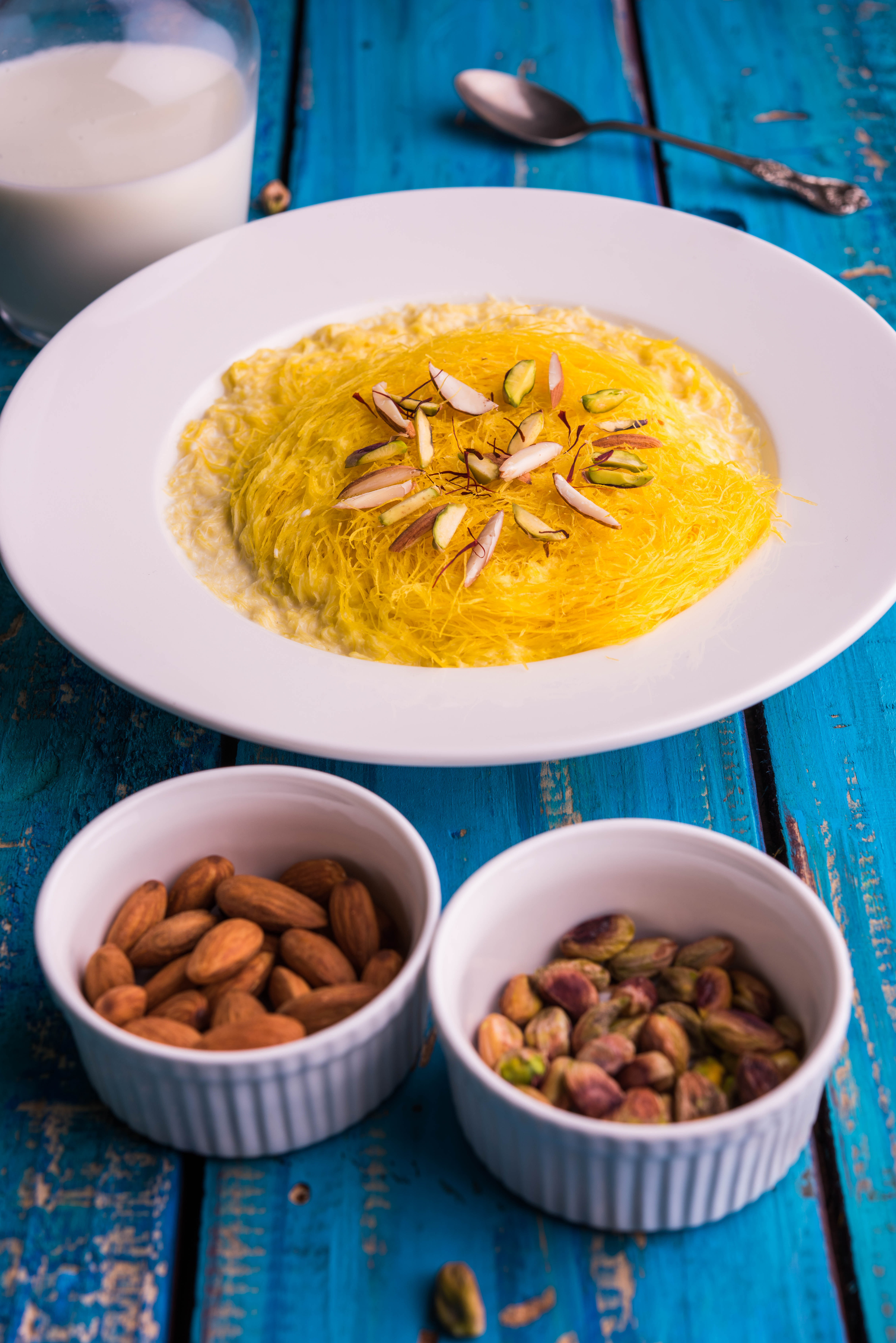 Overhead flat-lay of all ingredients for Moroccan Seffa Medfouna with Almonds and Raisins laid out on a kitchen surface.