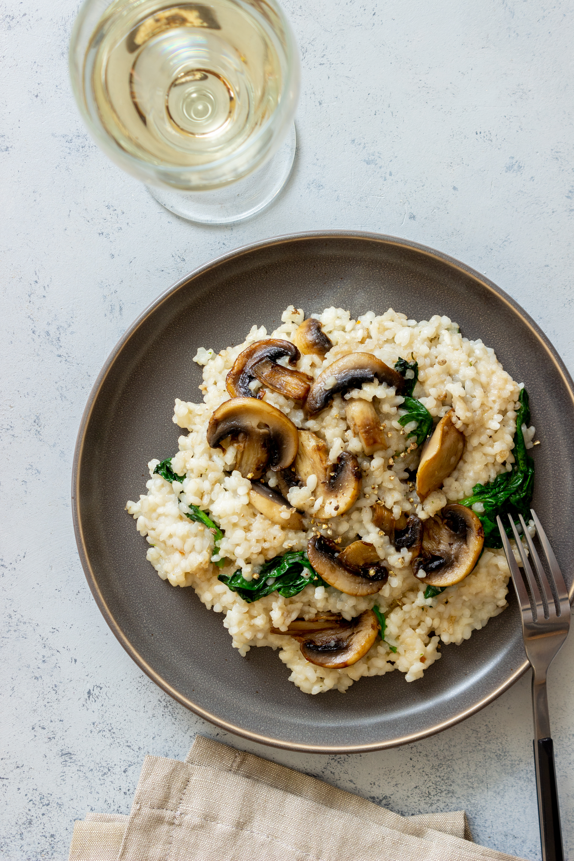 Overhead flat-lay of all ingredients for Mushroom Truffle Risotto laid out on a kitchen surface.