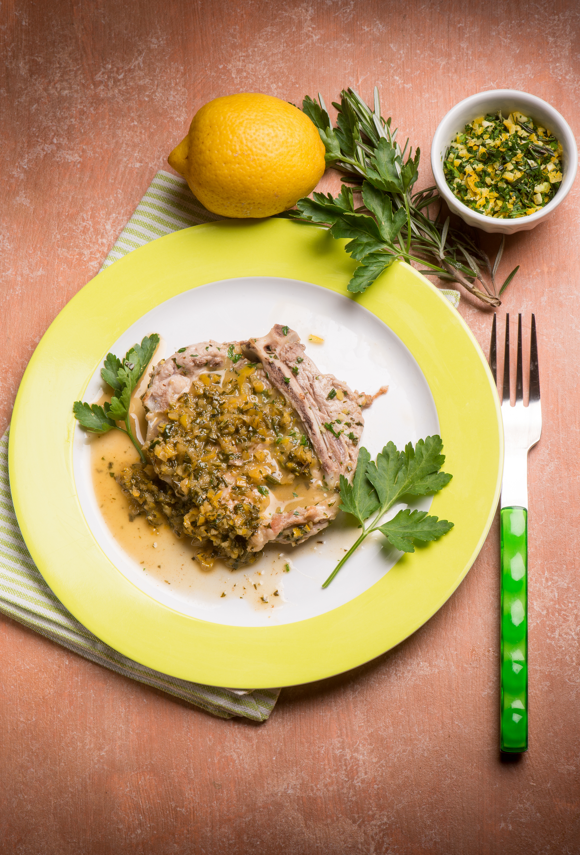 Overhead flat-lay of all ingredients for Ossobuco alla Milanese with Gremolata laid out on a kitchen surface.