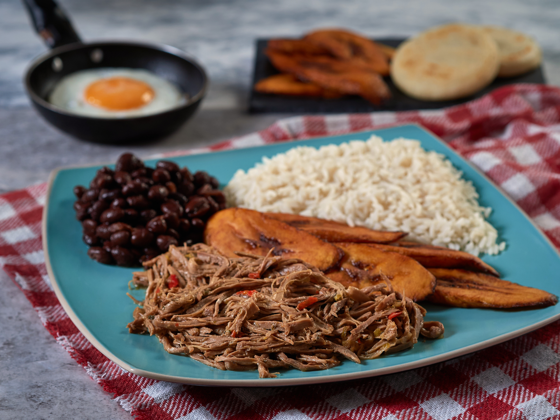Overhead flat-lay of all ingredients for Pabellón Criollo laid out on a kitchen surface.