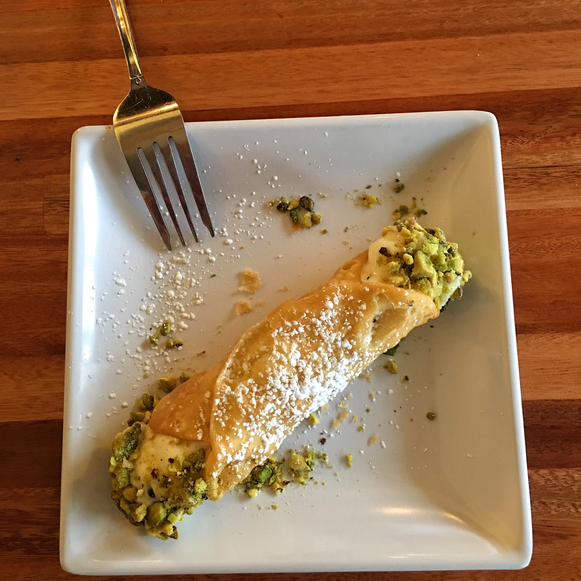 Overhead flat-lay of all ingredients for Rich Italian Cannoli with Ricotta and Pistachios laid out on a kitchen surface.