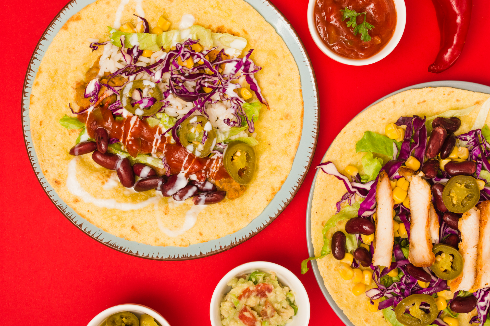 Overhead flat-lay of all ingredients for Rich Mexican Tinga Tostadas with Chipotle-Orange Salsa laid out on a kitchen surface.