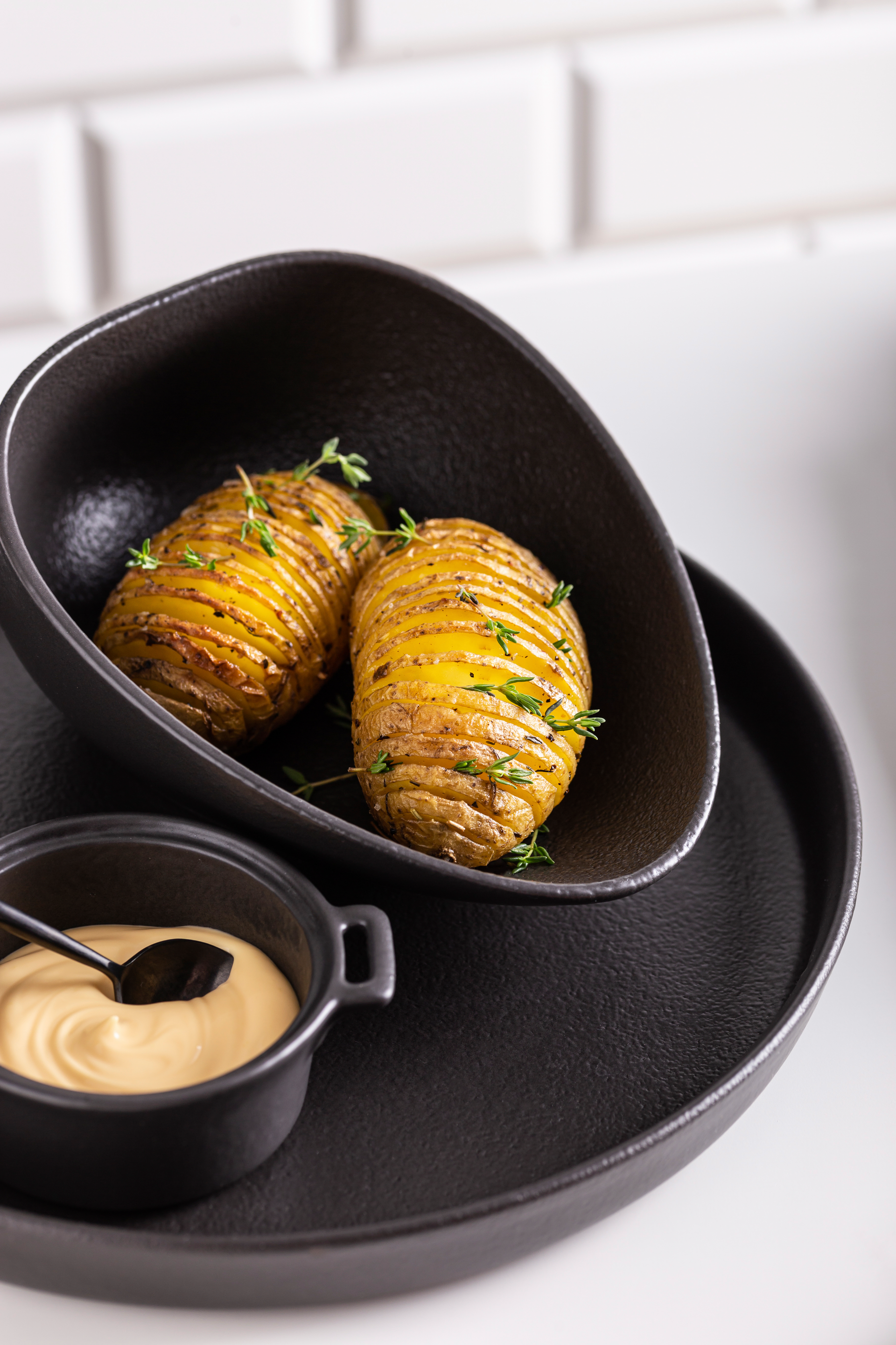 Overhead flat-lay of all ingredients for Rich Swedish Hasselback Potatoes with Garlic Butter laid out on a kitchen surface.