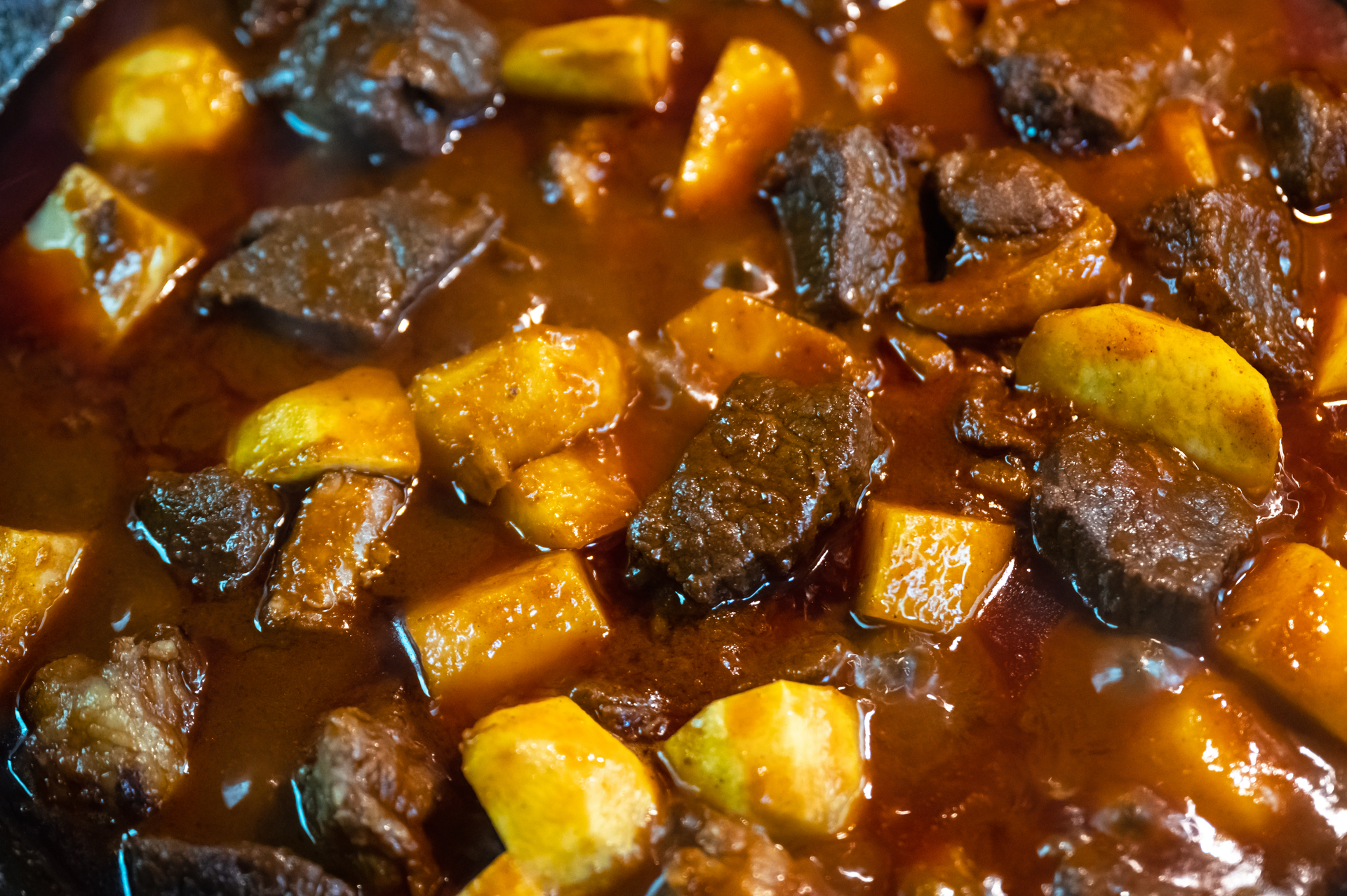 Overhead flat-lay of all ingredients for Roasted Jamaican Plantain and Coconut Beef Stew laid out on a kitchen surface.