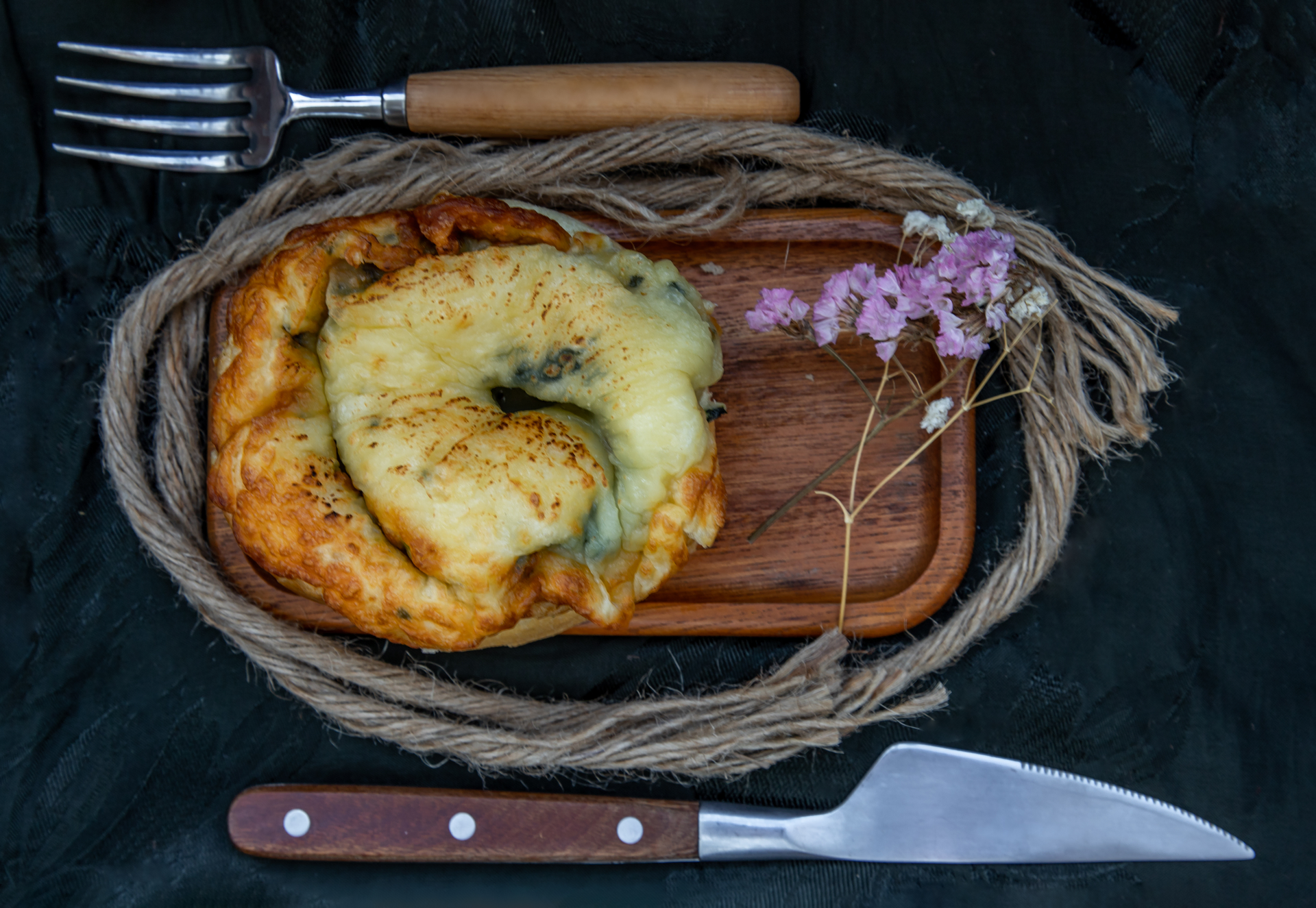 Overhead flat-lay of all ingredients for Rustic Argentinian Provoleta with Herbs and Garlic laid out on a kitchen surface.