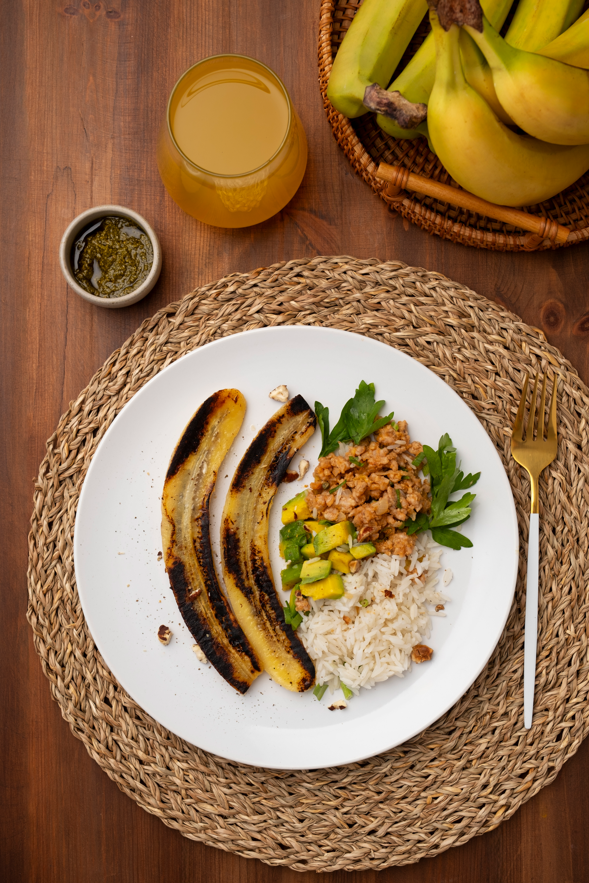 Overhead flat-lay of all ingredients for Rustic Colombian Bandeja Paisa with Plantains and Avocado laid out on a kitchen surface.