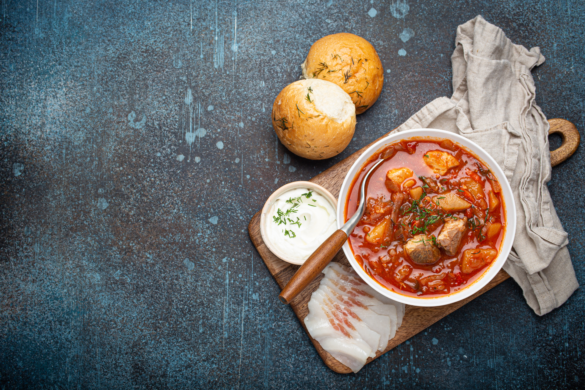 Overhead flat-lay of all ingredients for Rustic Hungarian Pörkölt with Paprika and Dumplings laid out on a kitchen surface.