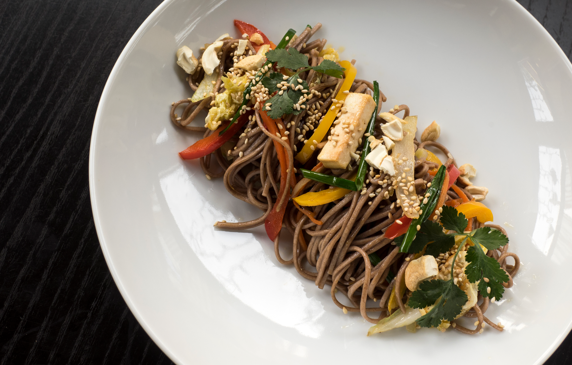 Overhead flat-lay of all ingredients for Rustic Japanese Soba Noodles with Vegetables and Sesame laid out on a kitchen surface.