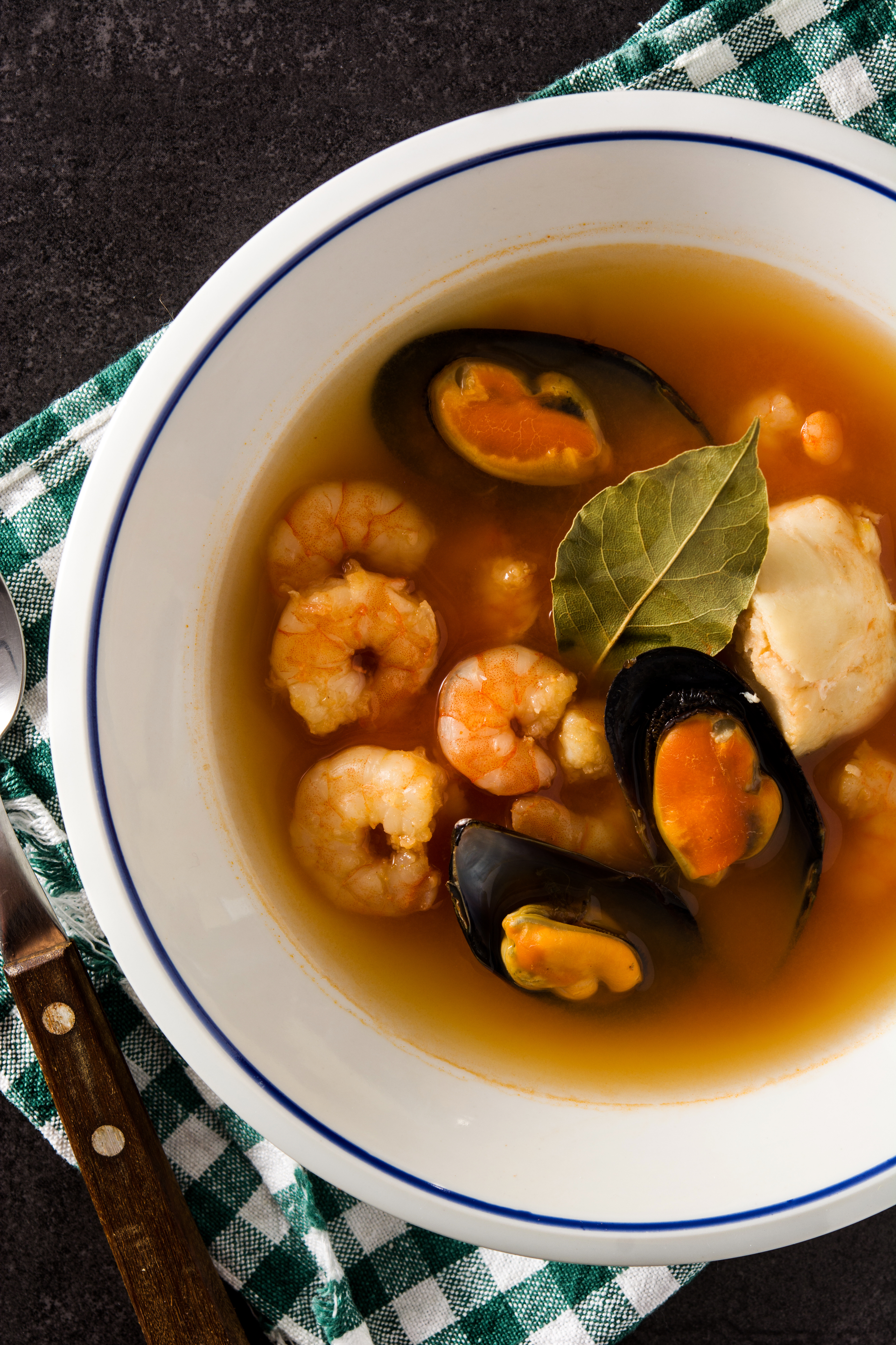 Overhead flat-lay of all ingredients for Rustic Portuguese Açorda de Marisco with Shellfish Infusion laid out on a kitchen surface.