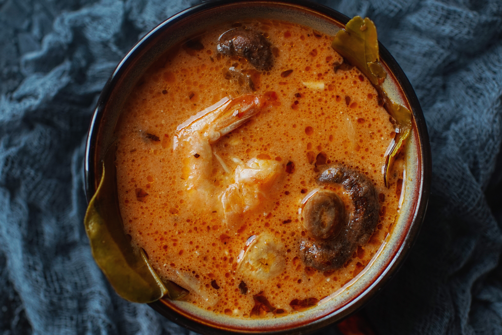 Overhead flat-lay of all ingredients for Rustic Spanish Seafood Caldereta with Saffron and Paprika laid out on a kitchen surface.