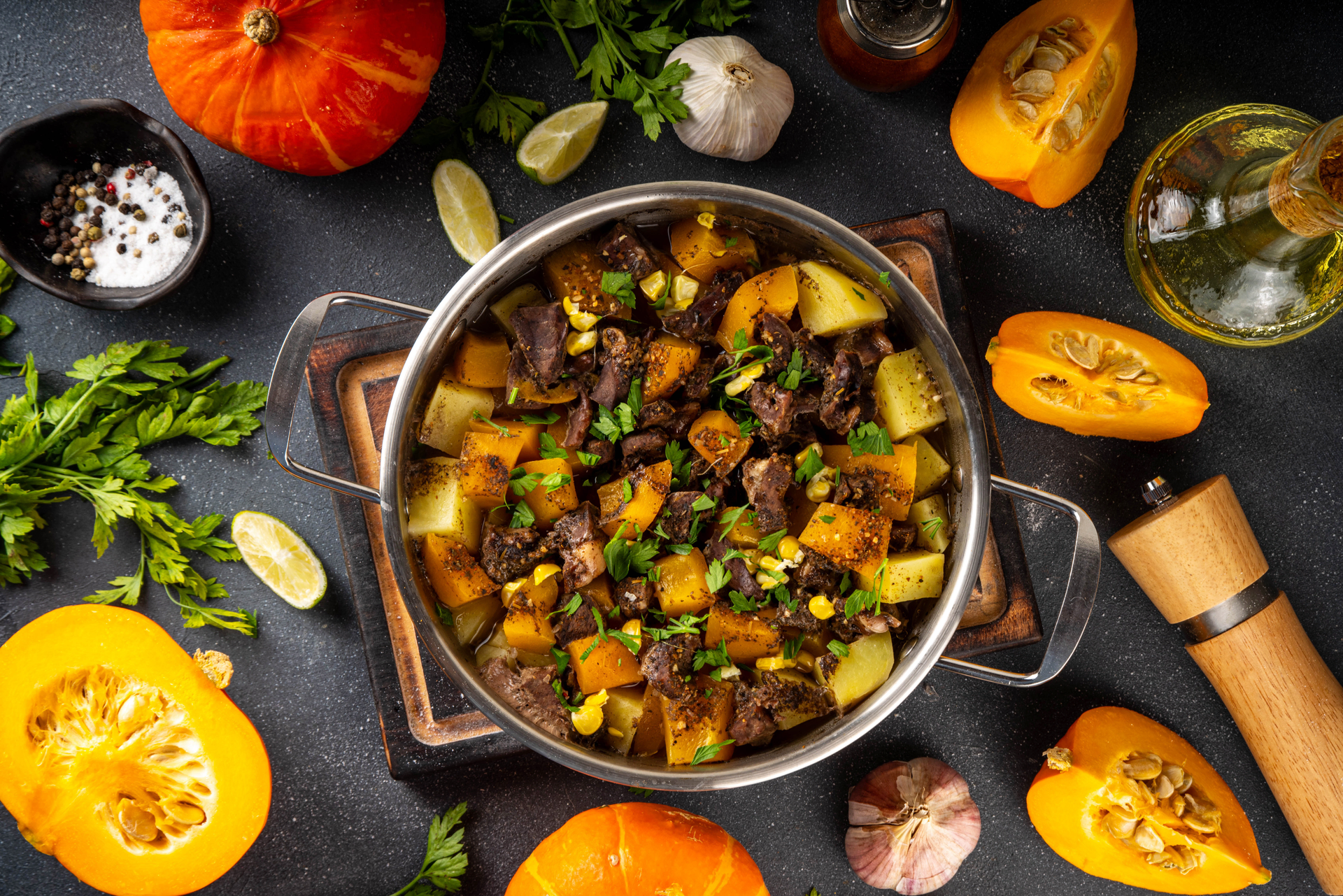 Overhead flat-lay of all ingredients for Savory Argentine Carbonada Criolla with Beef and Pumpkin laid out on a kitchen surface.